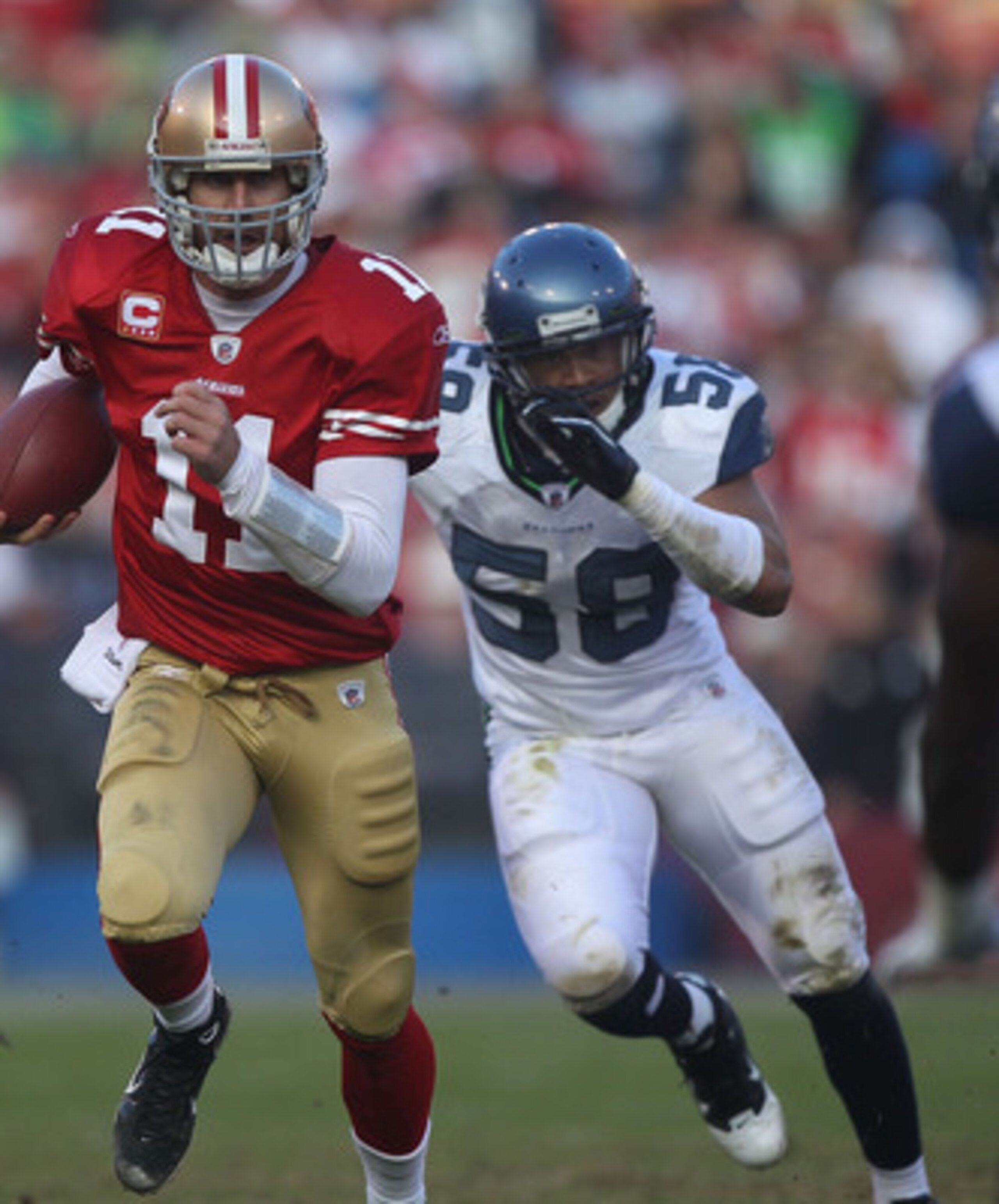 SAN FRANCISCO - DECEMBER 12:    Alex Smith #11 of the San Francisco 49ers runs with the ball against Dexter Davis #58 of the Seattle Seahawks during an NFL game at Candlestick Park on December 12, 2010 in San Francisco, California.  (Photo by Jed Jacobsoh