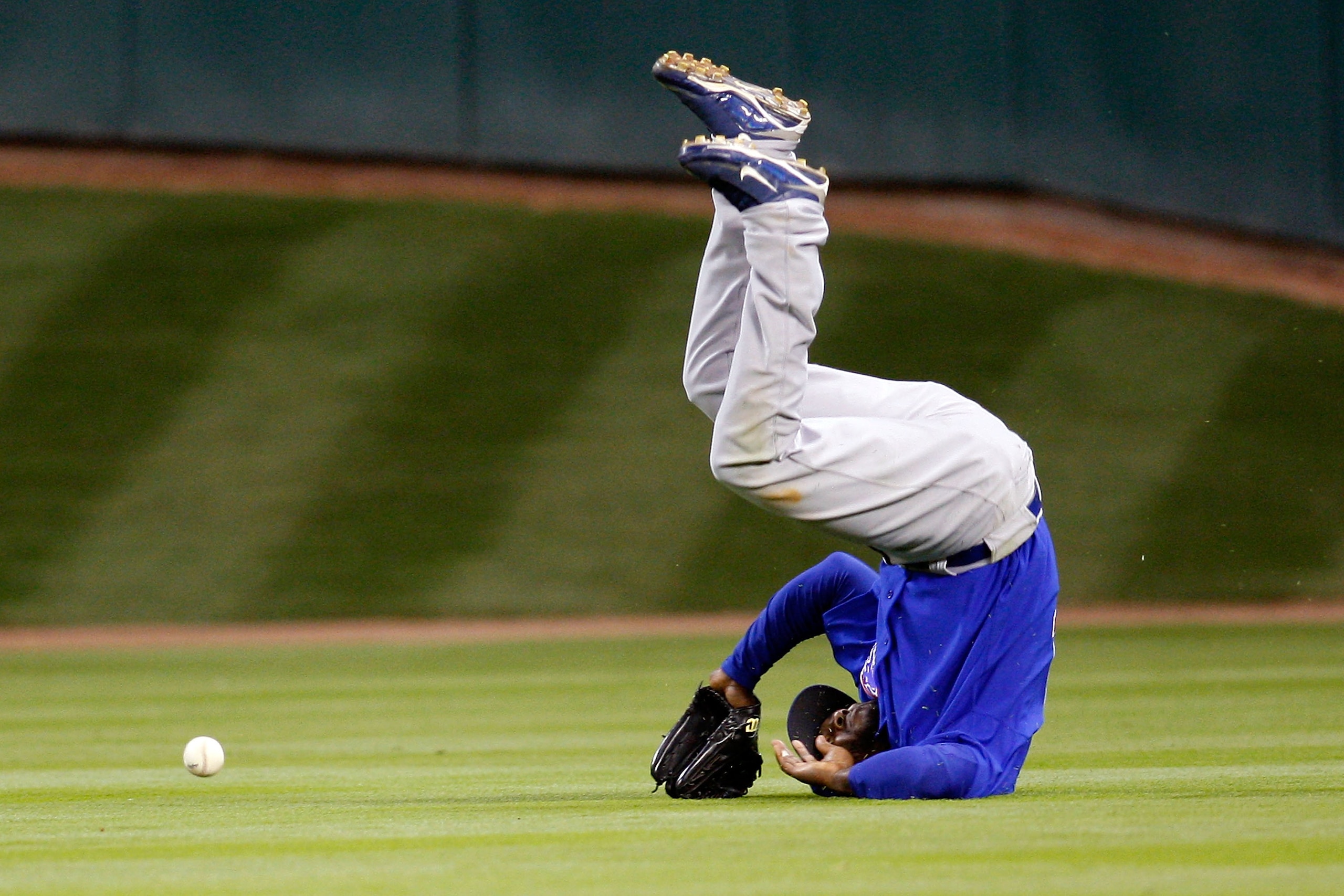 HOUSTON - APRIL 06:  Milton Bradley #21 of the Chicago Cubs flips over after missing a fly ball against the Houston Astros on Opening Day on April 6, 2009 at Minute Maid Park in Houston, Texas.  The Cubs defeated the Astros 4-2.  (Photo by Chris Graythen/