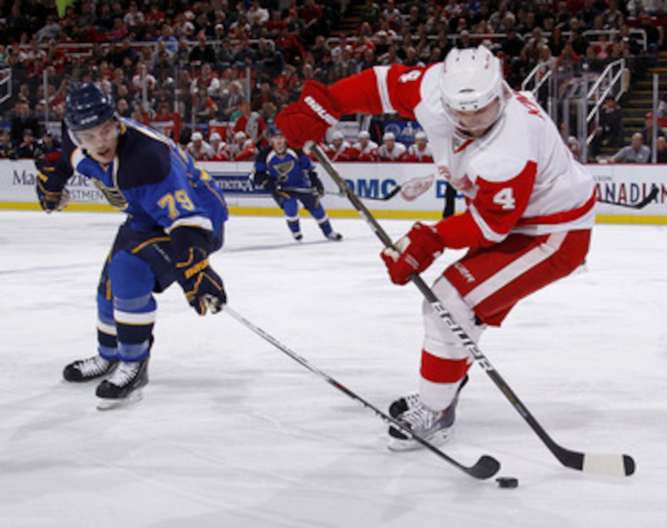 DETROIT, MI - MARCH 30: Jakub Kindl #4 of the Detroit Red Wings tries to keep the puck from the stick of Adam Cracknell #79 of the St. Louis Blues at Joe Louis Arena on March 30, 2011 in Detroit, Michigan.  (Photo by Gregory Shamus/Getty Images)