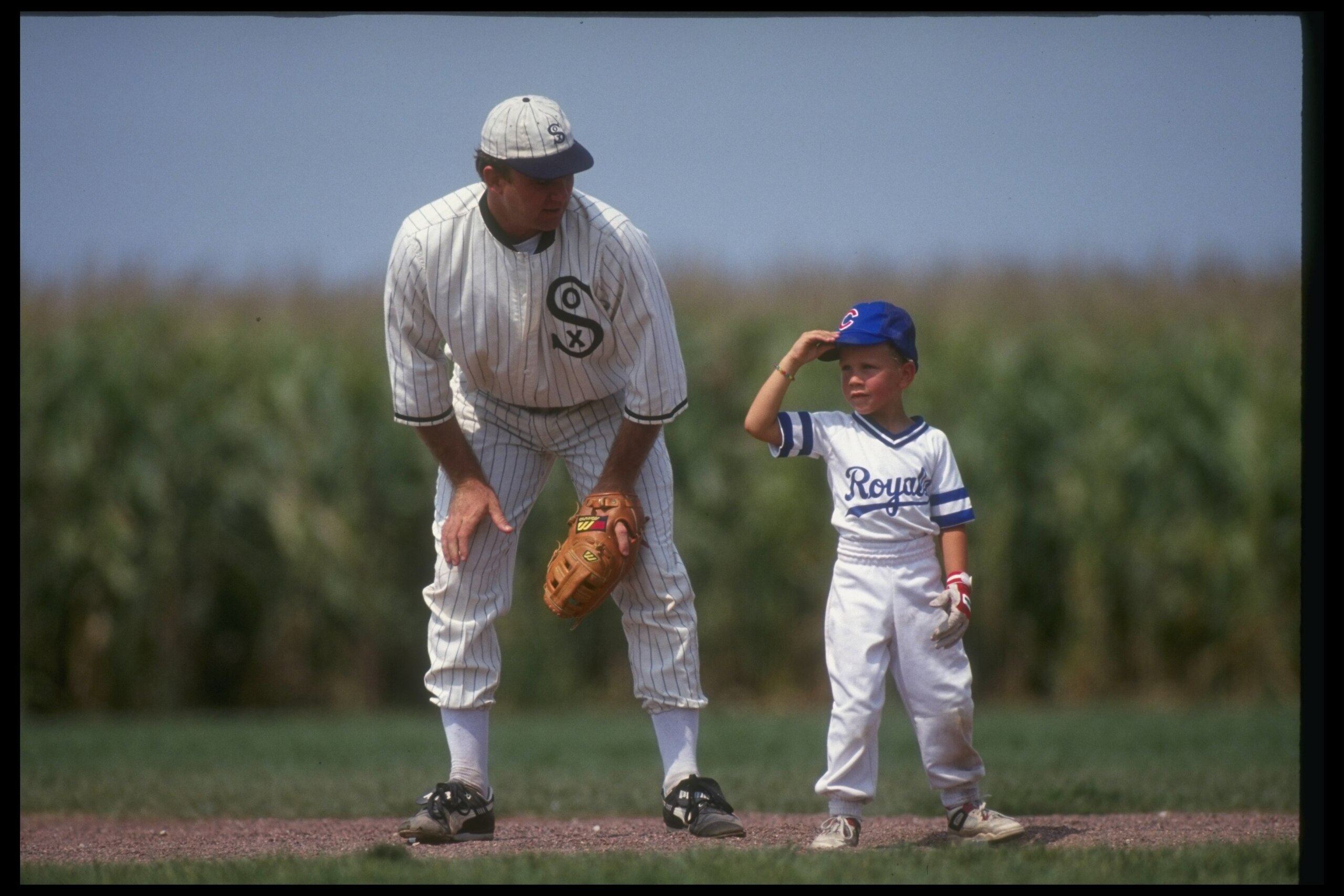 DYERSVILLE, IA - AUGUST 25: A 'ghost player' recreating the role of Chicago White Sox legend Shoeless Joe Jackson plays ball with a young tourist at the baseball field created for the motion picture 'Field of Dreams' on August 25, 1991 in Dyersville, Iowa