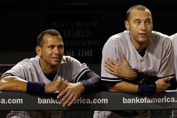 BALTIMORE, MD - APRIL 23:  Alex Rodriguez #13 of the New York Yankees (L) Derek Jeter #2 (C) and manager Joe Girardi #28 (R) look out from the dugout during the eighth inning of their 15-3 win over the Baltimore Orioles at Oriole Park at Camden Yards on A