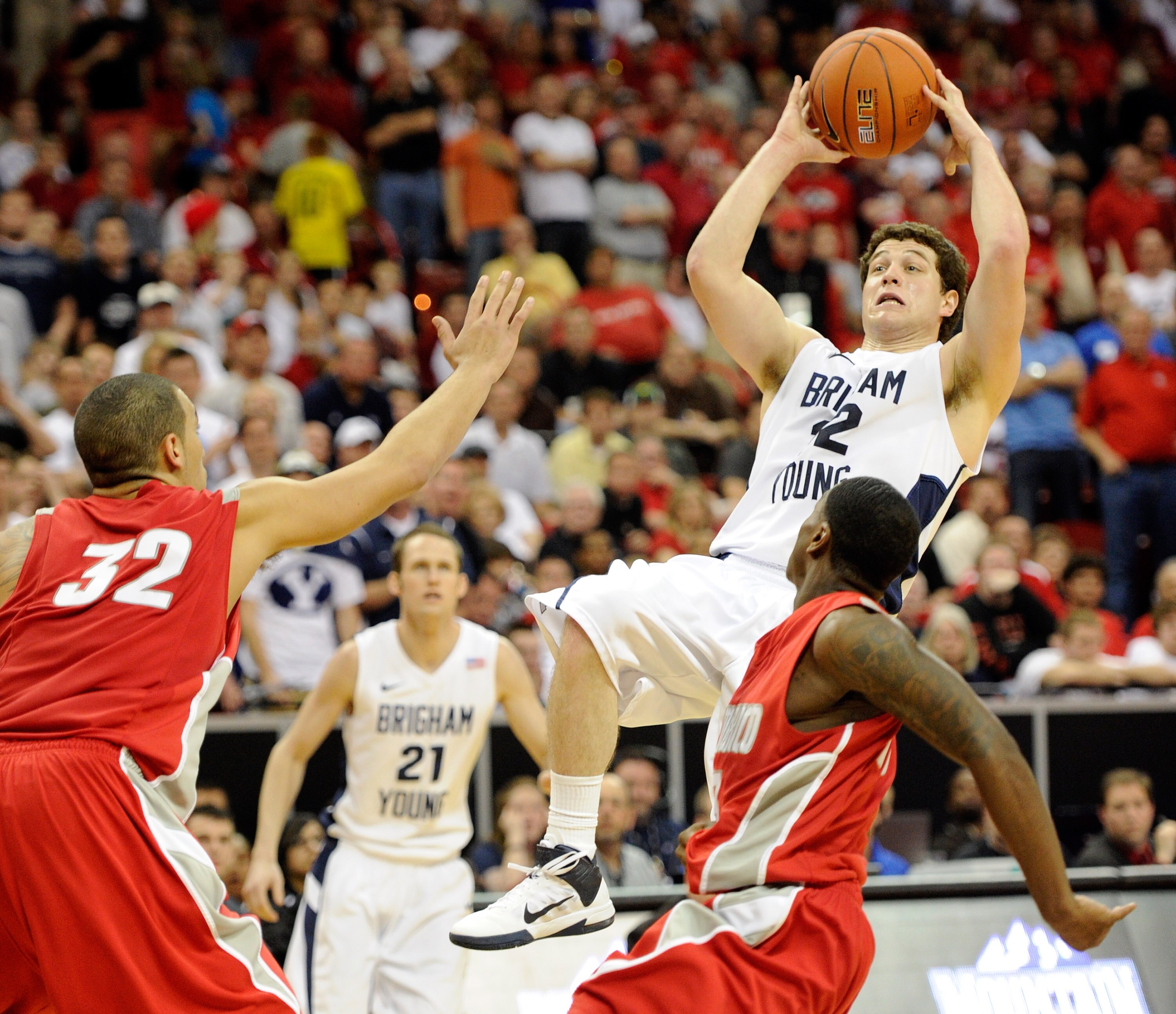 LAS VEGAS, NV - MARCH 11:  Jimmer Fredette #32 of the Brigham Young University Cougars shoots against Drew Gordon #32 and Jamal Fenton #13 of the New Mexico Lobos during a semifinal game of the Conoco Mountain West Conference Basketball tournament at the