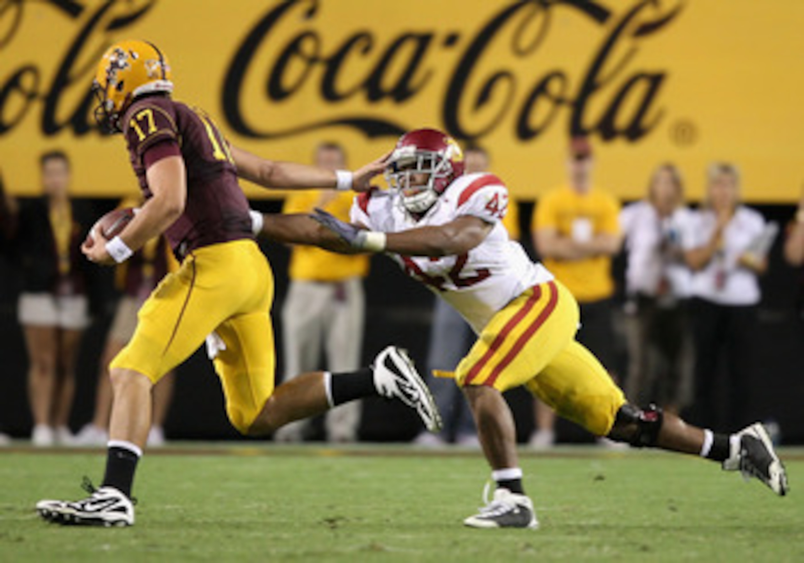 TEMPE, AZ - NOVEMBER 07:  Quarterback Brock Osweiler #17 of the Arizona State Sun Devils scrambles with the ball past Devon Kennard #42 of the USC Trojans during the college football game at Sun Devil Stadium on November 7, 2009 in Tempe, Arizona.  The Tr