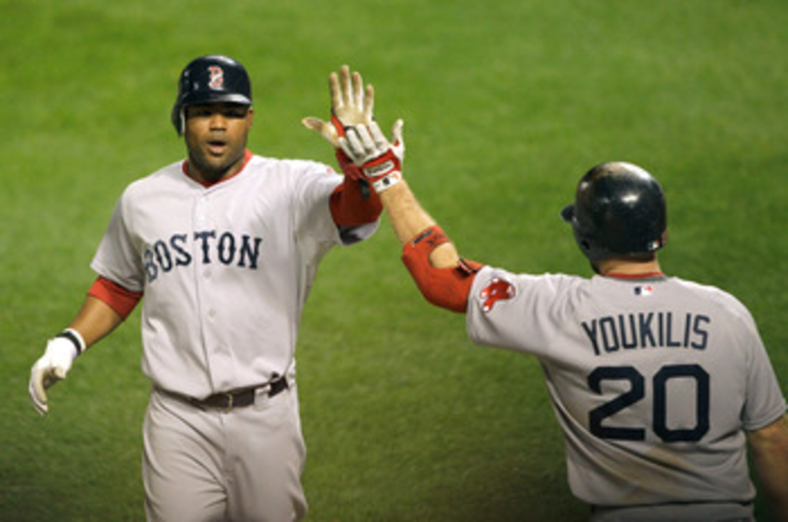 BALTIMORE, MD - APRIL 28: Carl Crawford #13 of the Boston Red Sox (L) celebrates with teammate Kevin Youkilis #20 after scoring against the Baltimore Orioles during the seventh inning at Oriole Park at Camden Yards on April 28, 2011 in Baltimore, Maryland