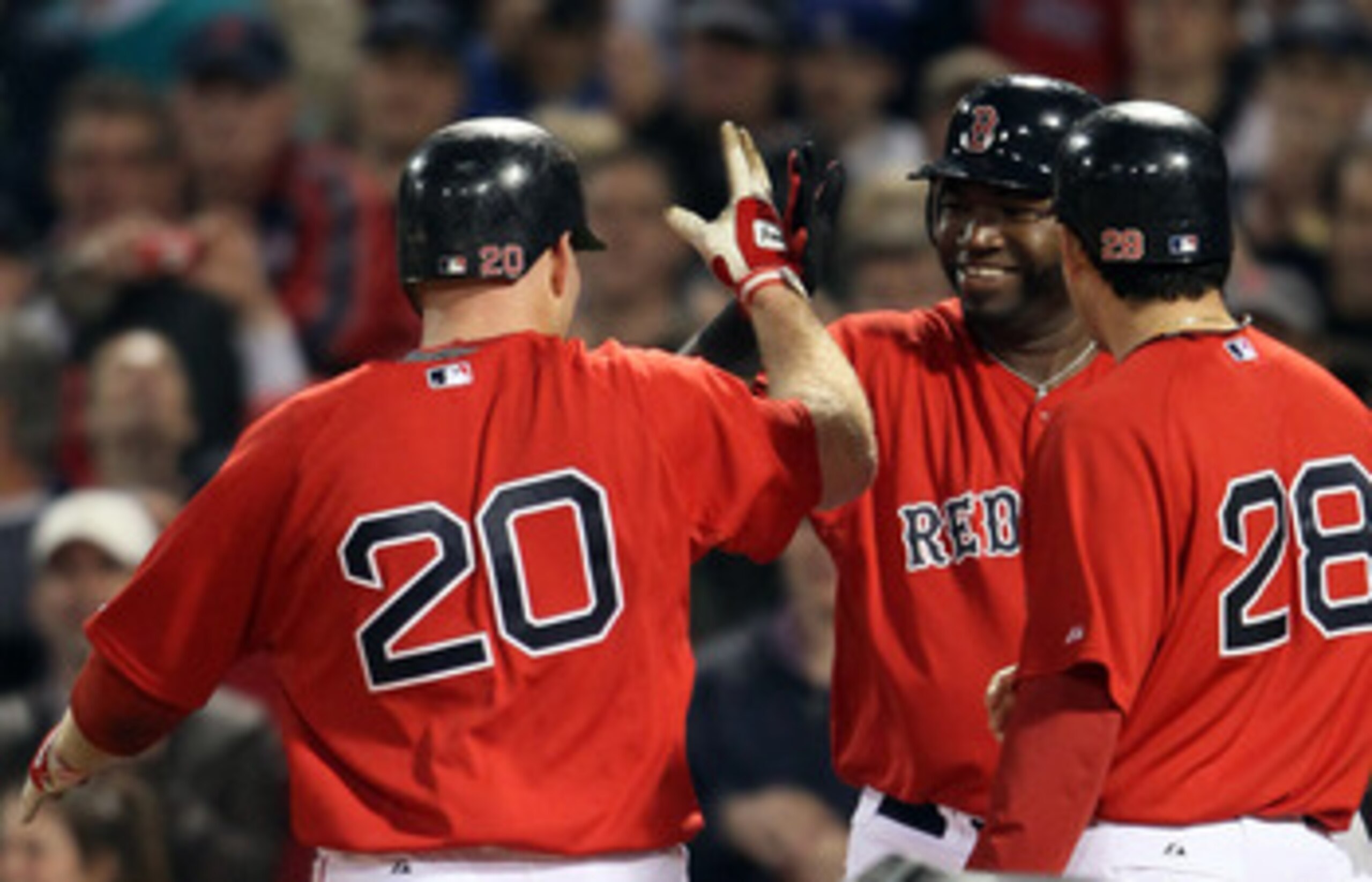 BOSTON, MA - MAY 20:  David Ortiz #34 of the Boston Red Sox congratulates Kevin Youkilis #20 and Adrian Gonzalez #28 after Youkils hit a two run homer against the Chicago Cubs on May 20, 2011 at Fenway Park in Boston, Massachusetts.on May 20, 2011 at Fenw