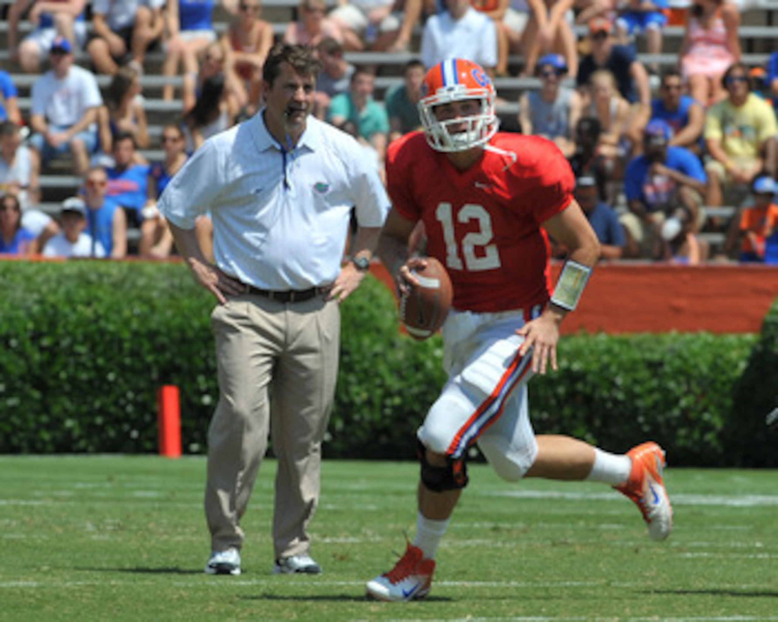 GAINESVILLE, FL - APRIL 9: Quarterback John Brantley #12 of the Florida Gators runs from the pocket in front of coach Will Muschamp during the Orange and Blue spring football game April 9, 2011 at Ben Hill Griffin Stadium in Gainesville, Florida. (Photo GAINESVILLE, FL - APRIL 9: Quarterback John Brantley #12 of the Florida Gators runs from the pocket in front of coach Will Muschamp during the Orange and Blue spring football game April 9, 2011 at Ben Hill Griffin Stadium in Gainesville, Florida. (Photo