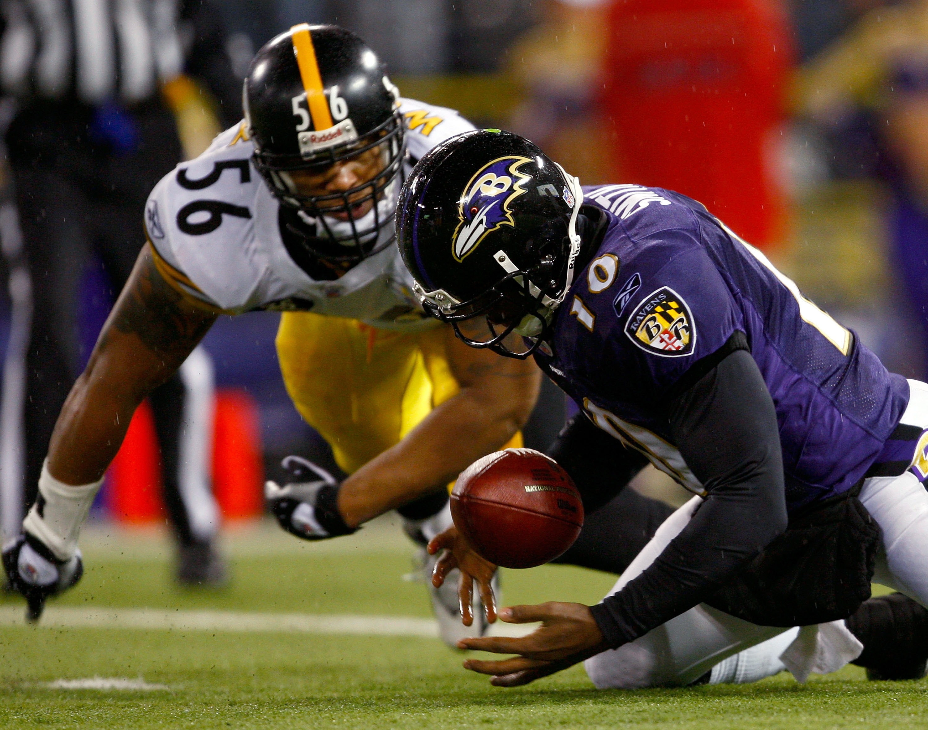 BALTIMORE - DECEMBER 30:  Quarterback Troy Smith #10 of the Baltimore Ravens falls on a loose ball as linebacker LaMarr Woodley #56 of the Pittsburgh Steelers defends during the game at M&T Bank Stadium December 30, 2007 in Baltimore, Maryland.  (Photo by