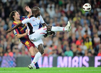 BARCELONA, SPAIN - OCTOBER 03:  Gabriel Milito of Barcelona (L) duels for a high ball with Pierre Webo of Mallorca reacts during the La Liga match between Barcelona and Mallorca at the Camp Nou stadium on October 3, 2010 in Barcelona, Spain. The match end
