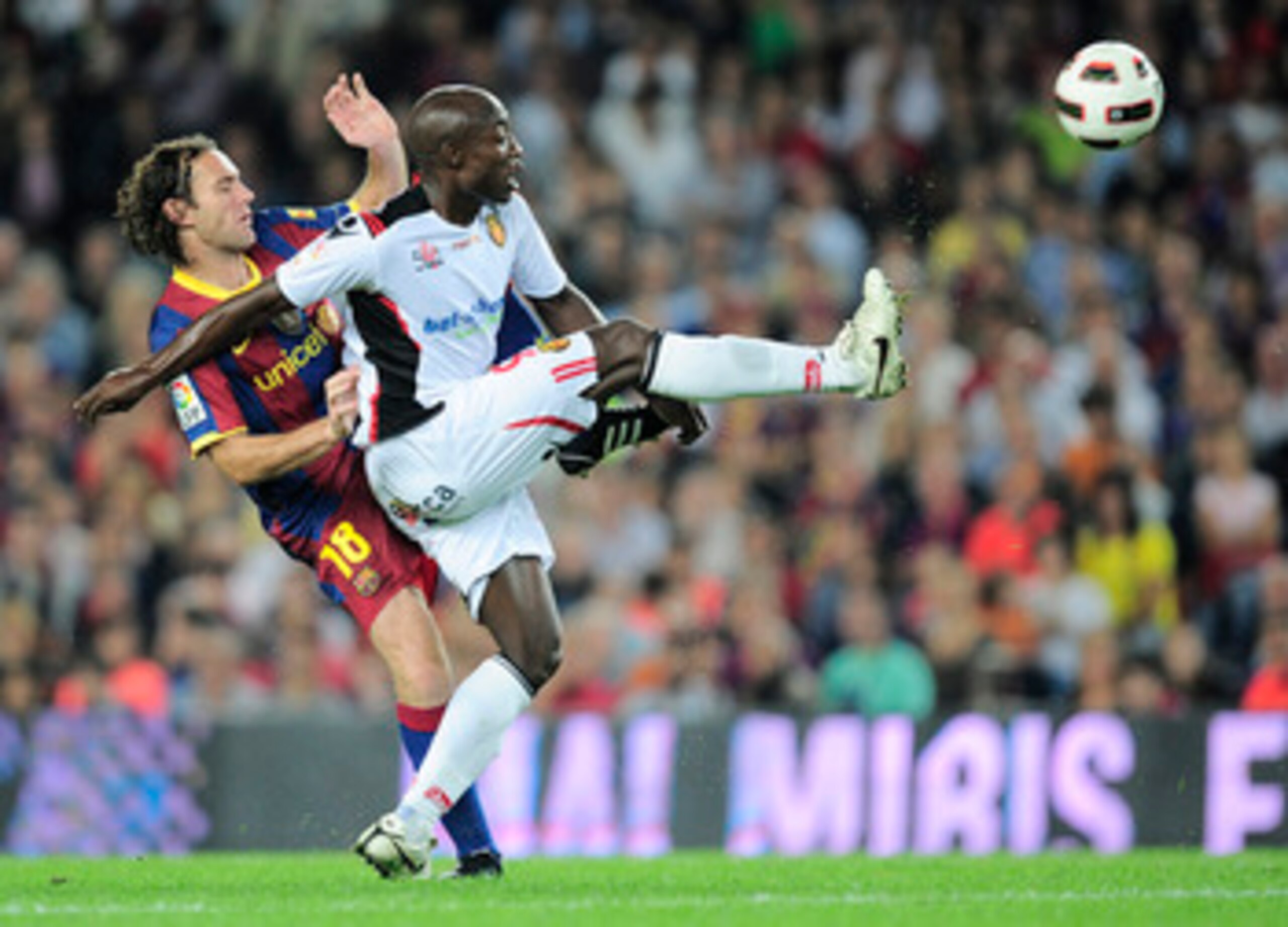 BARCELONA, SPAIN - OCTOBER 03:  Gabriel Milito of Barcelona (L) duels for a high ball with Pierre Webo of Mallorca reacts during the La Liga match between Barcelona and Mallorca at the Camp Nou stadium on October 3, 2010 in Barcelona, Spain. The match end