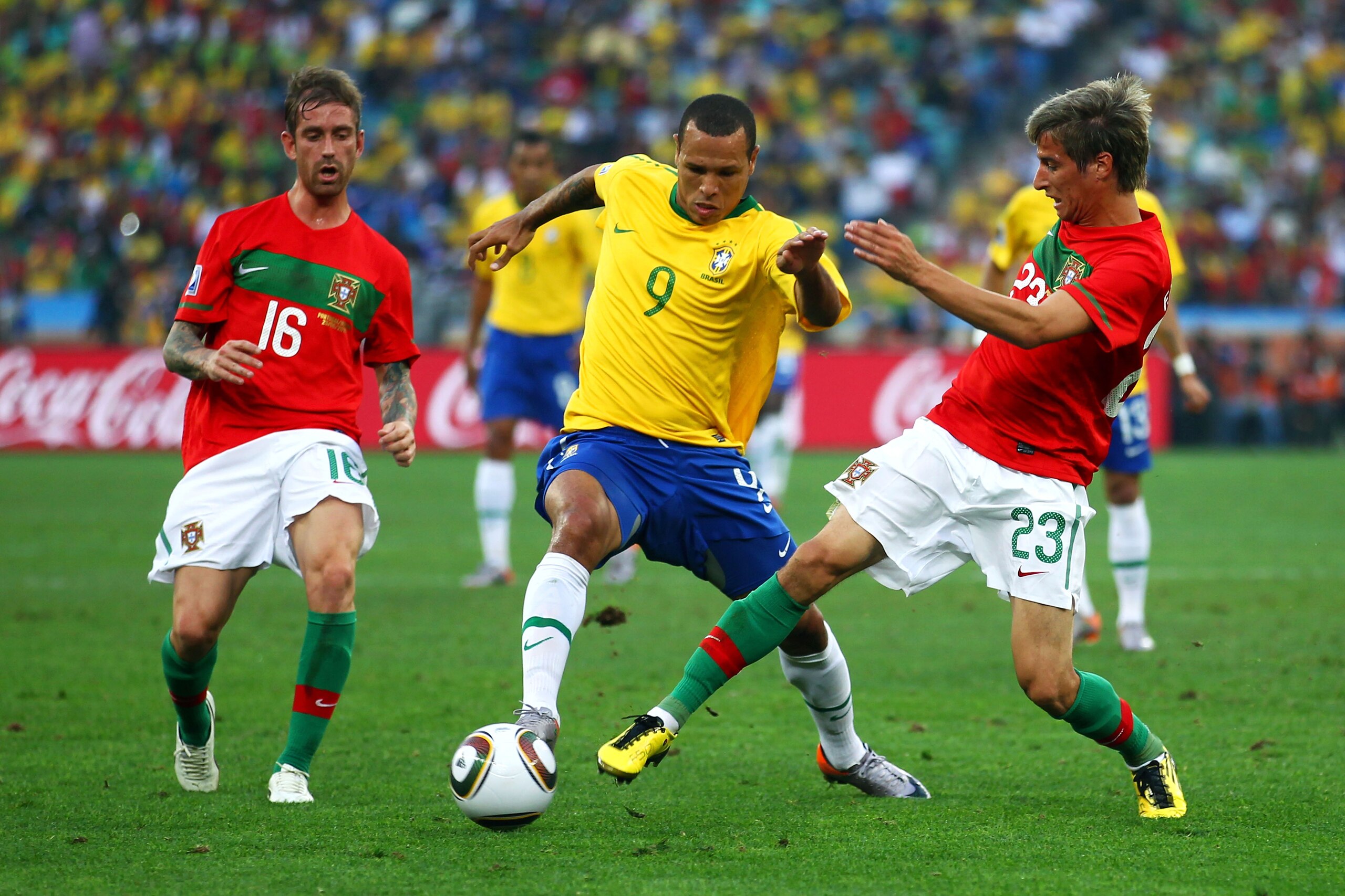 DURBAN, SOUTH AFRICA - JUNE 25: Luis Fabiano of Brazil is challenged by Raul Meireles (L) and Fabio Coentrao (R) of Portugal during the 2010 FIFA World Cup South Africa Group G match between Portugal and Brazil at Durban Stadium on June 25, 2010 in Durban