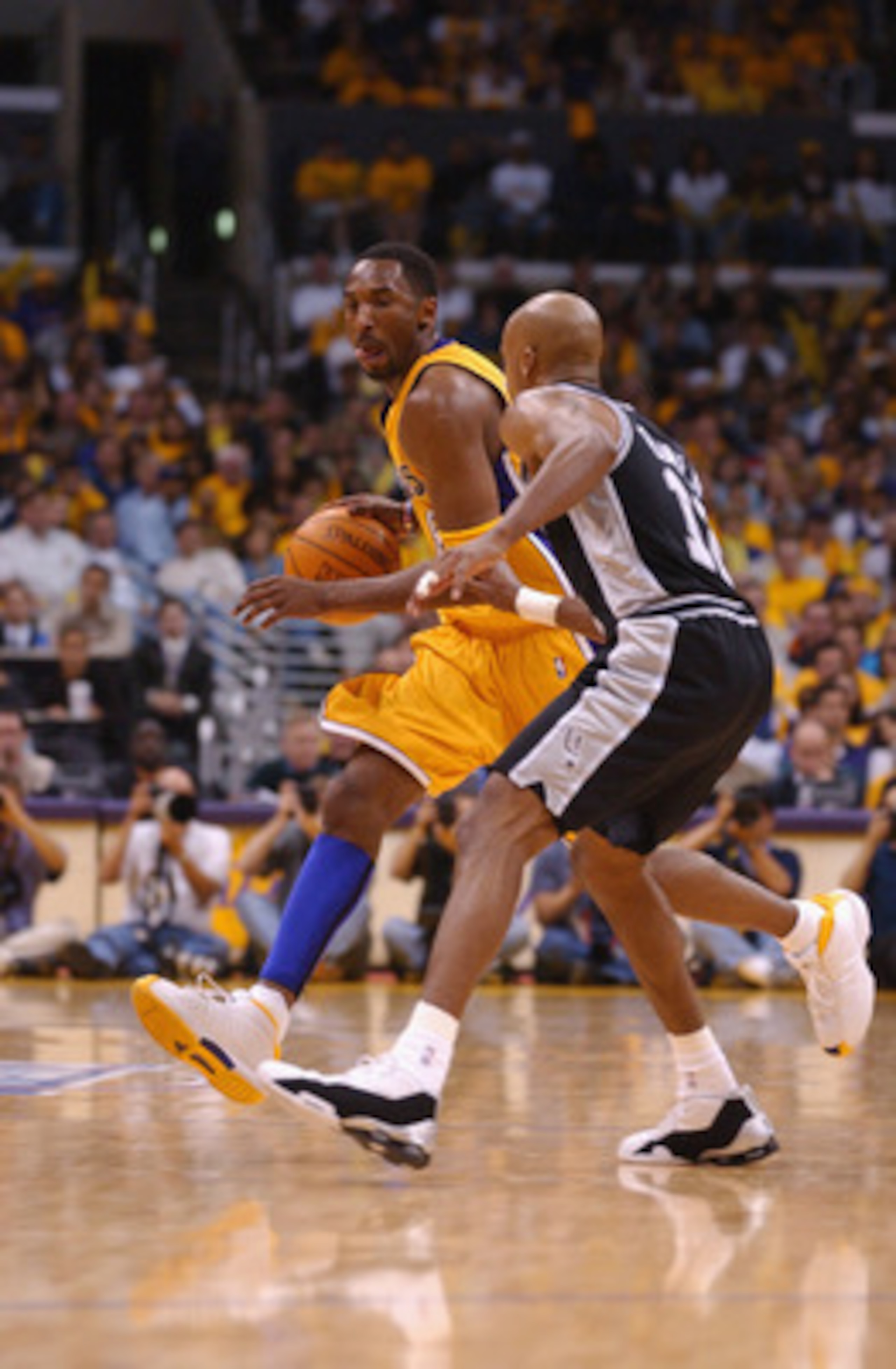 LOS ANGELES - MAY 5:  Guard Kobe Bryant #8 of the Los Angeles Lakers drives past guard Bruce Bowen #12 of the San Antonio Spurs during game one of the Western Conference Semifinals during the 2002 NBA Playoffs at Staples Center in Los Angeles, California 