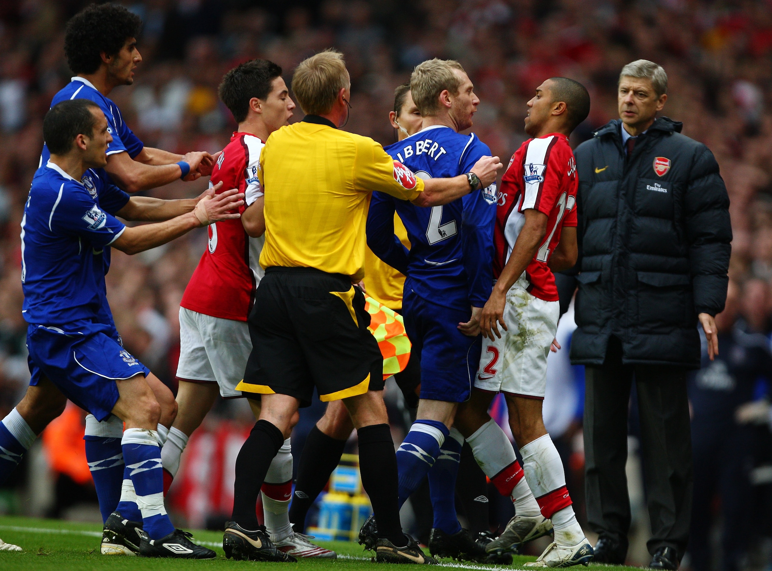 LONDON - OCTOBER 18:  Gael Clichy of Arsenal and Tony Hibbert of Everton square up in front of Arsene Wenger, manager of Arsenal and Referee Peter Walton during the Barclays Premier League match between Arsenal and Everton at Emirates Stadium on October 1