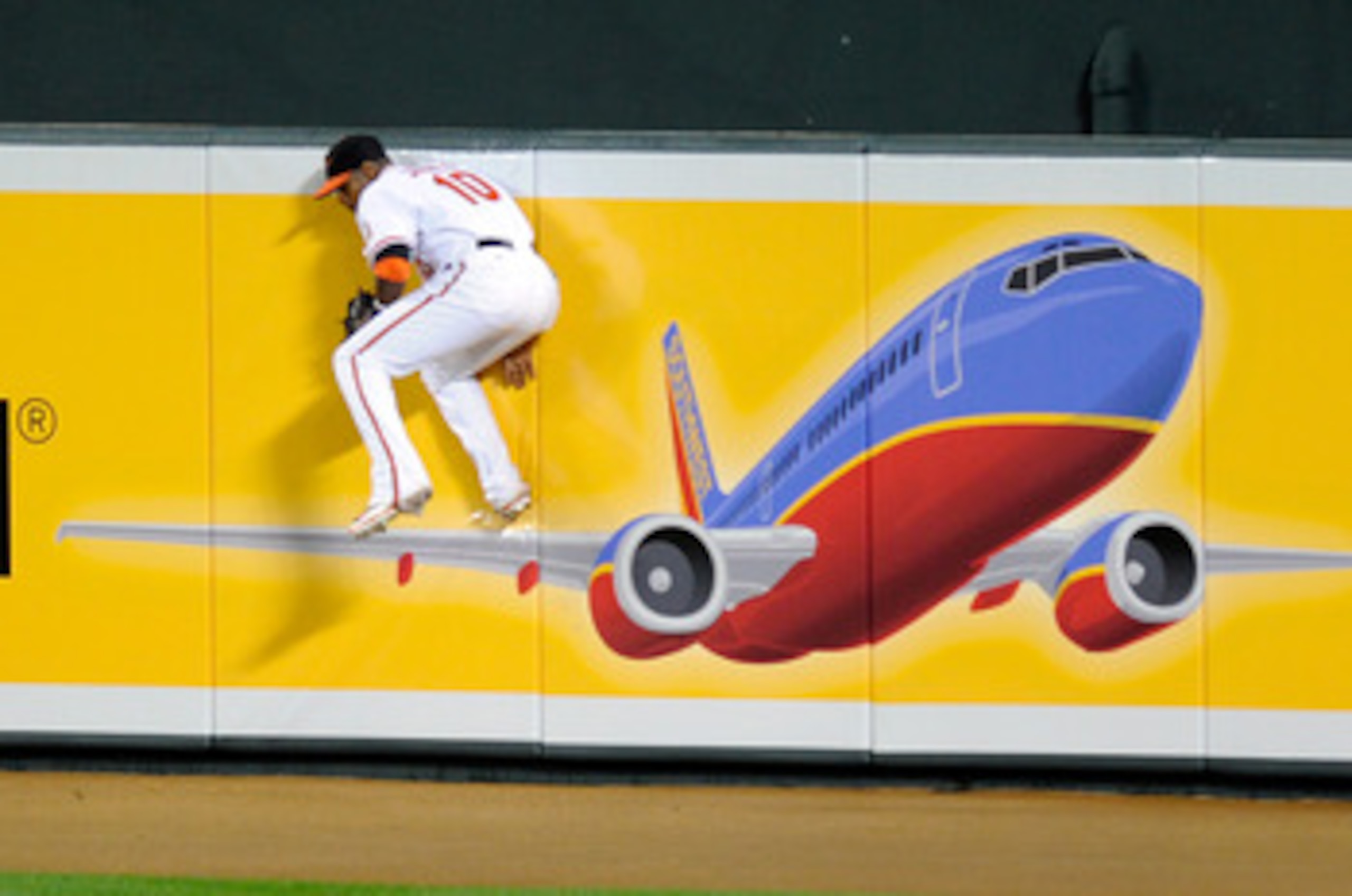 BALTIMORE, MD - MAY 19:  Adam Jones #10 of the Baltimore Orioles crashes into the wall after making a catch in the eighth inning against the New York Yankees at Oriole Park at Camden Yards on May 19, 2011 in Baltimore, Maryland. New York won the game 13-2