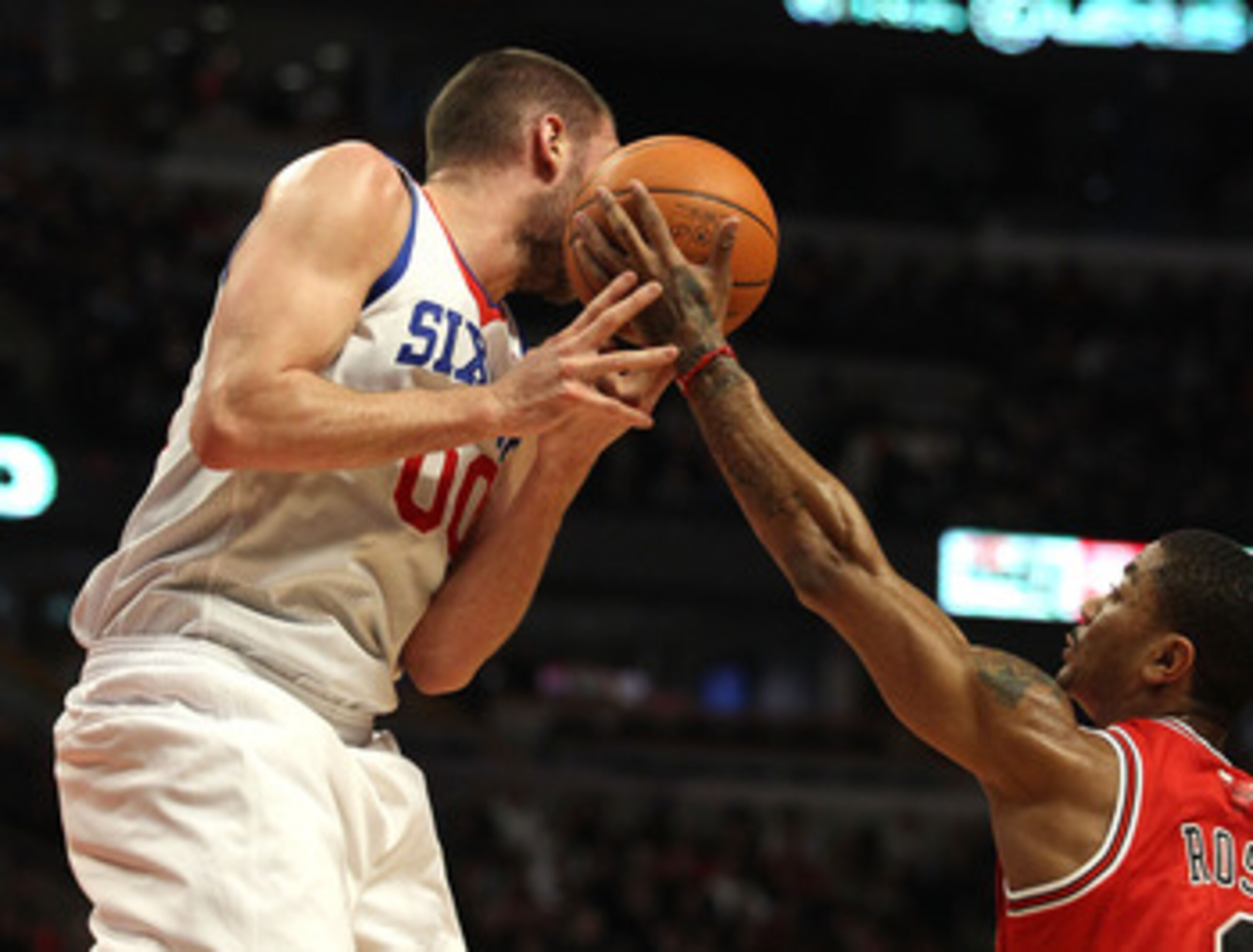 CHICAGO, IL - MARCH 28: Derrick Rose #1 of the Chicago Bulls reaches for the ball going off of the face of Spencer Hawes #00 of the Philadelphia 76ers at the United Center on March 28, 2011 in Chicago, Illinois. NOTE TO USER: User expressly acknowledges a CHICAGO, IL - MARCH 28: Derrick Rose #1 of the Chicago Bulls reaches for the ball going off of the face of Spencer Hawes #00 of the Philadelphia 76ers at the United Center on March 28, 2011 in Chicago, Illinois. NOTE TO USER: User expressly acknowledges a