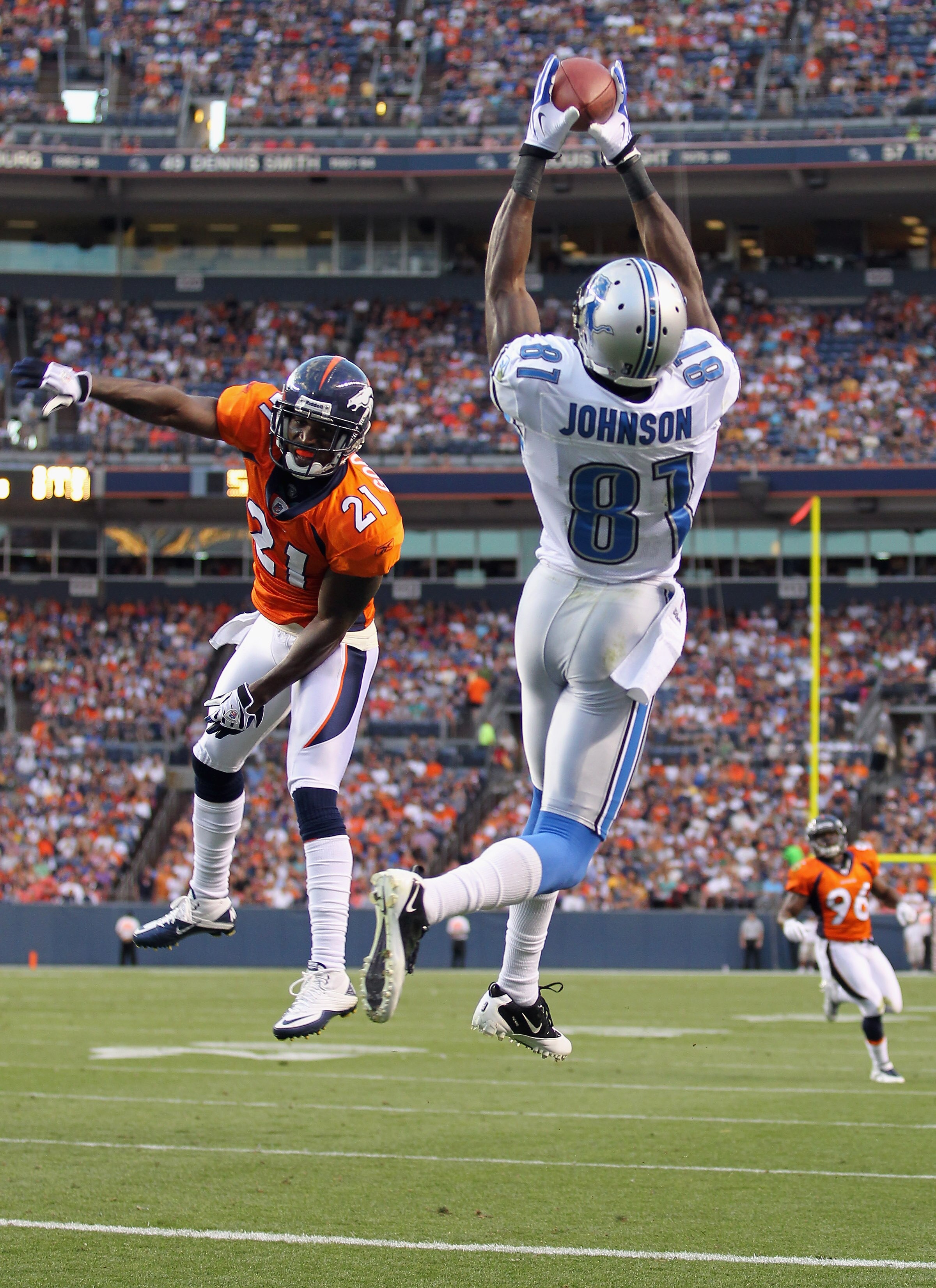 DENVER - AUGUST 21:  Calvin Johnson  #81 of the Detroit Lions makes a 20 yard touchdown catch as Andre Goodman #21 of the Denver Broncos during preseason NFL action at INVESCO Field at Mile High on August 21, 2010 in Denver, Colorado. The touchdown gave t