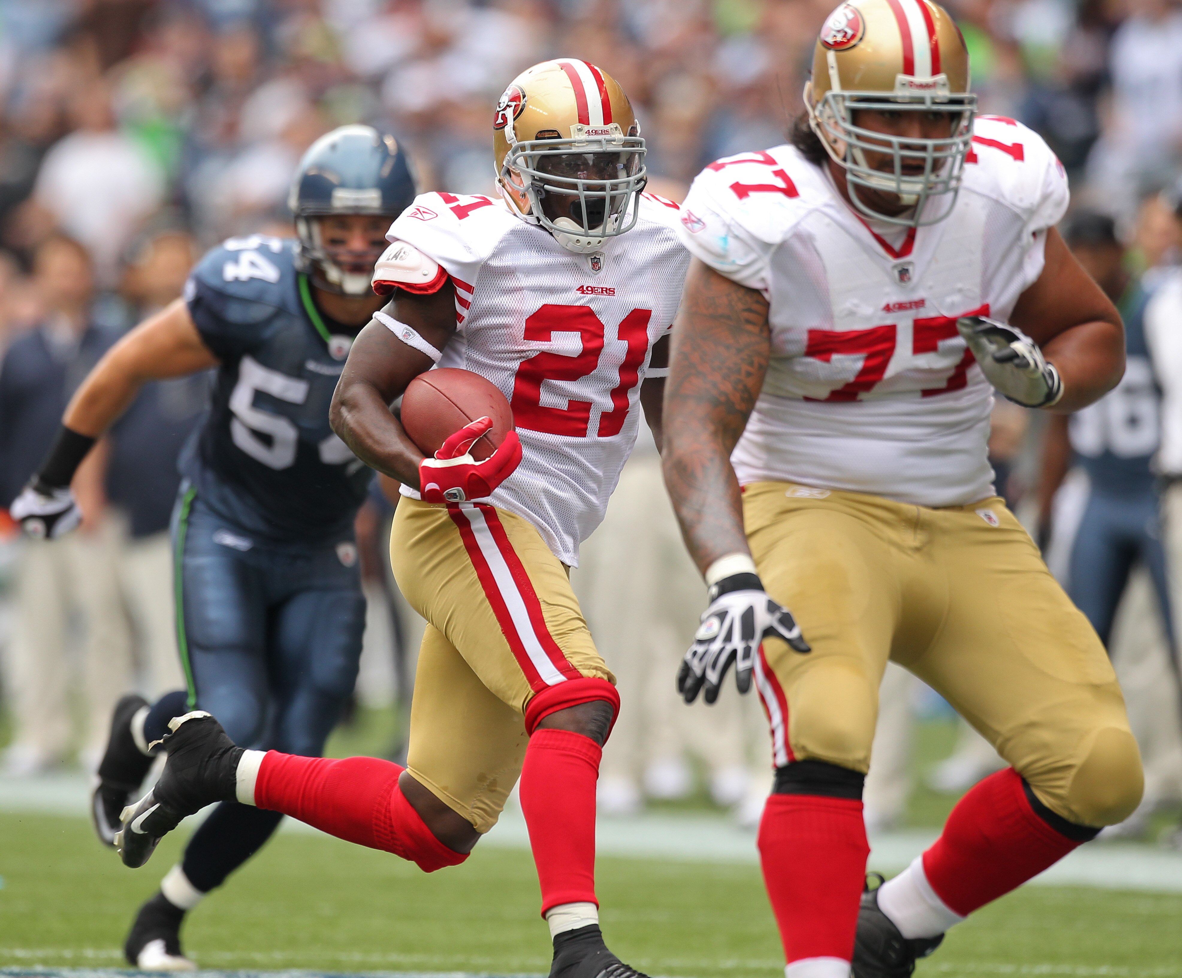 SEATTLE - SEPTEMBER 12:  Running back Frank Gore #21 of the San Francisco 49ers rushes as Mike Iupati #77 blocks for him during the NFL season opener against the Seattle Seahawks at Qwest Field on September 12, 2010 in Seattle, Washington. (Photo by Otto