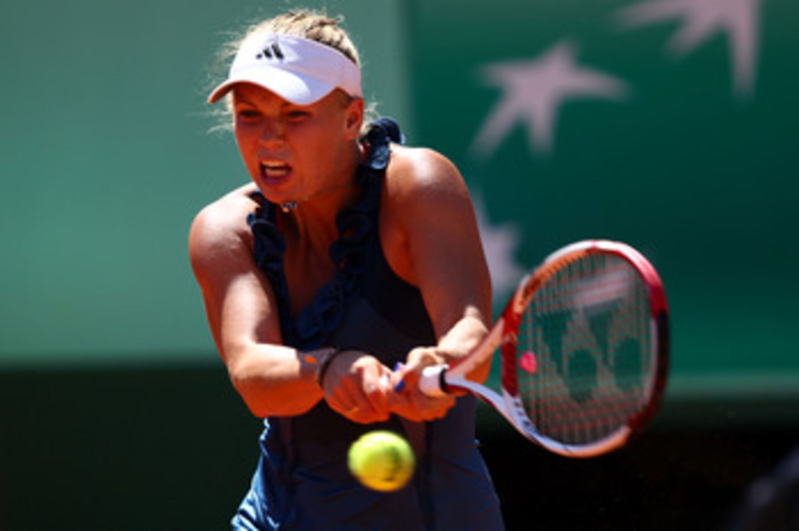 PARIS, FRANCE - MAY 25:  Caroline Wozniacki of Denmark hits a backhand during the women's singles round two match between Caroline Wozniacki of Denmark and Aleksandra Wozniak of Canada on day four of the French Open at Roland Garros on May 25, 2011 in Par