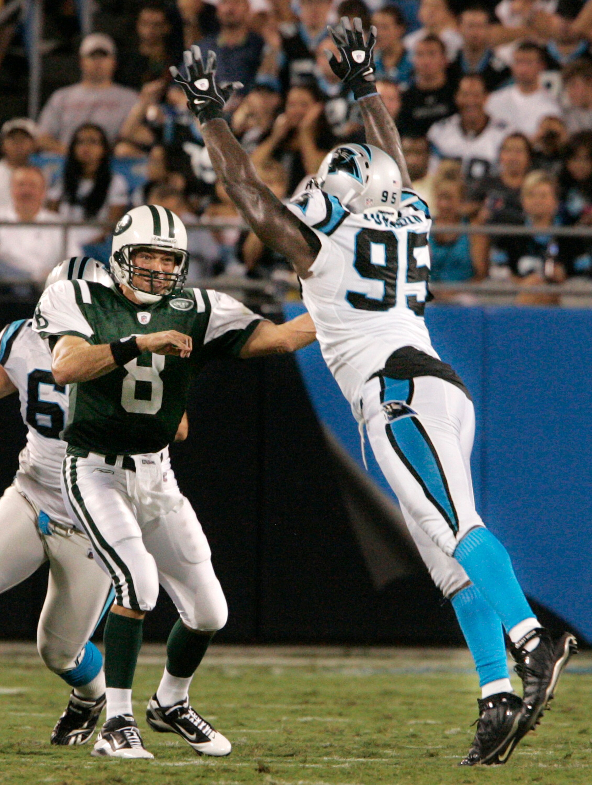 CHARLOTTE, NC - AUGUST 21:  Quarterback Mark Brunell #8 of the New York Jets throw under pressure from Charles Johnson #95 of the Carolina Panthers during their preseason game at Bank of America Stadium on August 21, 2010 in Charlotte, North Carolina. (Ph