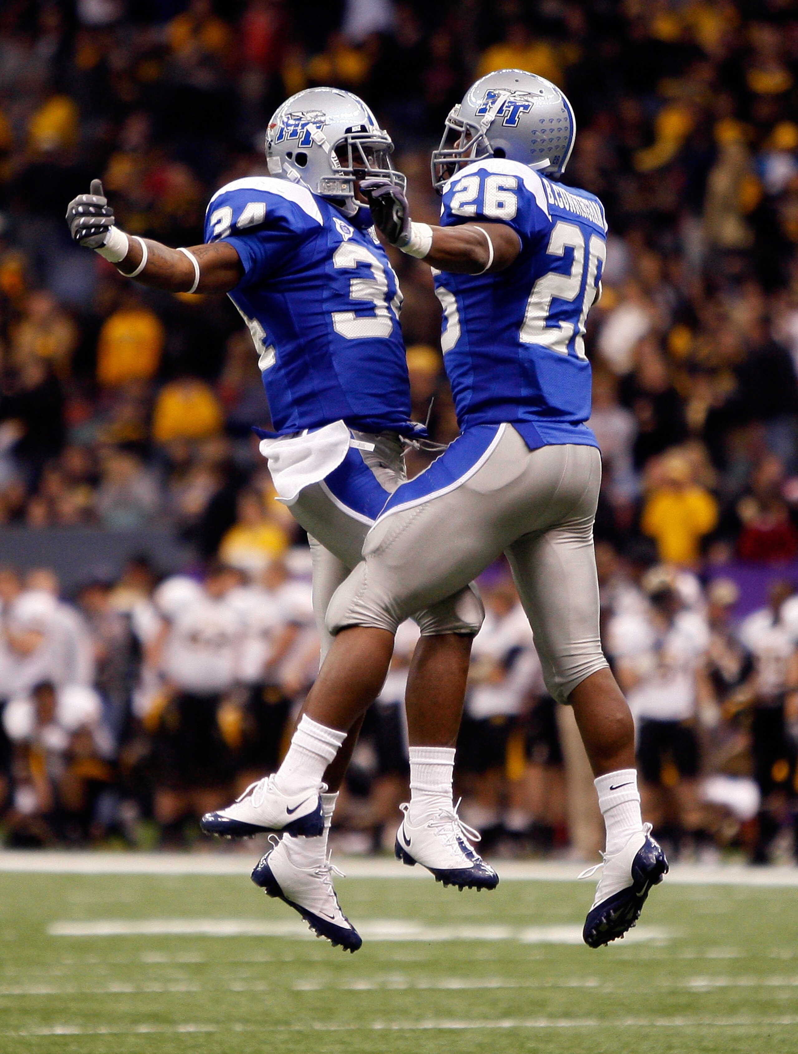 NEW ORLEANS - DECEMBER 20:   Marquise Branton #34 and Stuart Taylor #26 of the Middle Tennessee Blue Raiders celebrate after a touchdown against the Southern Miss Golden Eagles during the R+L Carriers New Orleans Bowl at the Louisiana Superdome on Decembe