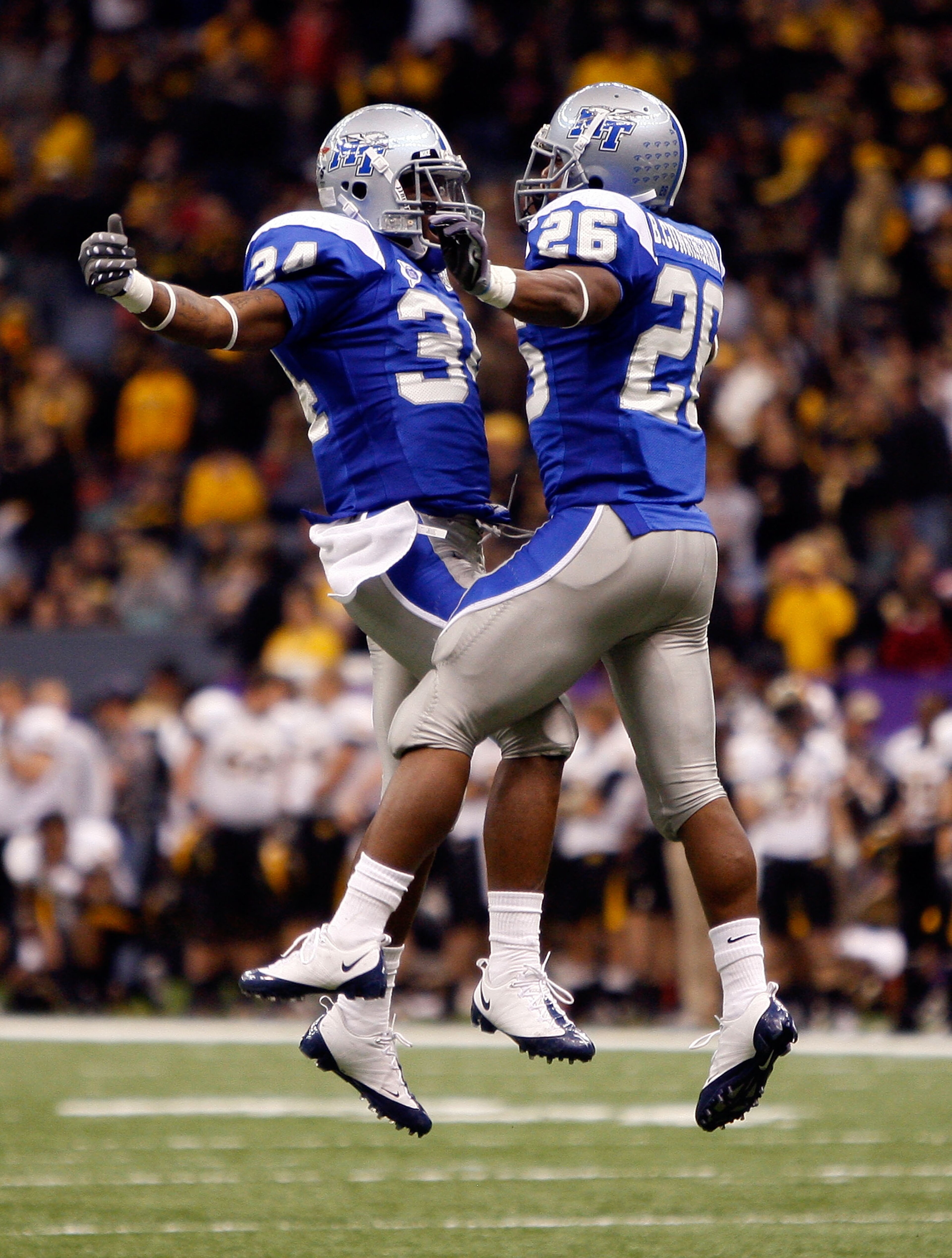 NEW ORLEANS - DECEMBER 20:   Marquise Branton #34 and Stuart Taylor #26 of the Middle Tennessee Blue Raiders celebrate after a touchdown against the Southern Miss Golden Eagles during the R+L Carriers New Orleans Bowl at the Louisiana Superdome on Decembe