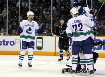 SAN JOSE, CA - MAY 22:  Henrik Sedin #33 of the Vancouver Canucks skates in to congratulate teammate Alex Burrows #14 and Daniel Sedin #22 after Burrows scored a goal against the San Jose Sharks in Game Four of the Western Conference Finals during the 201