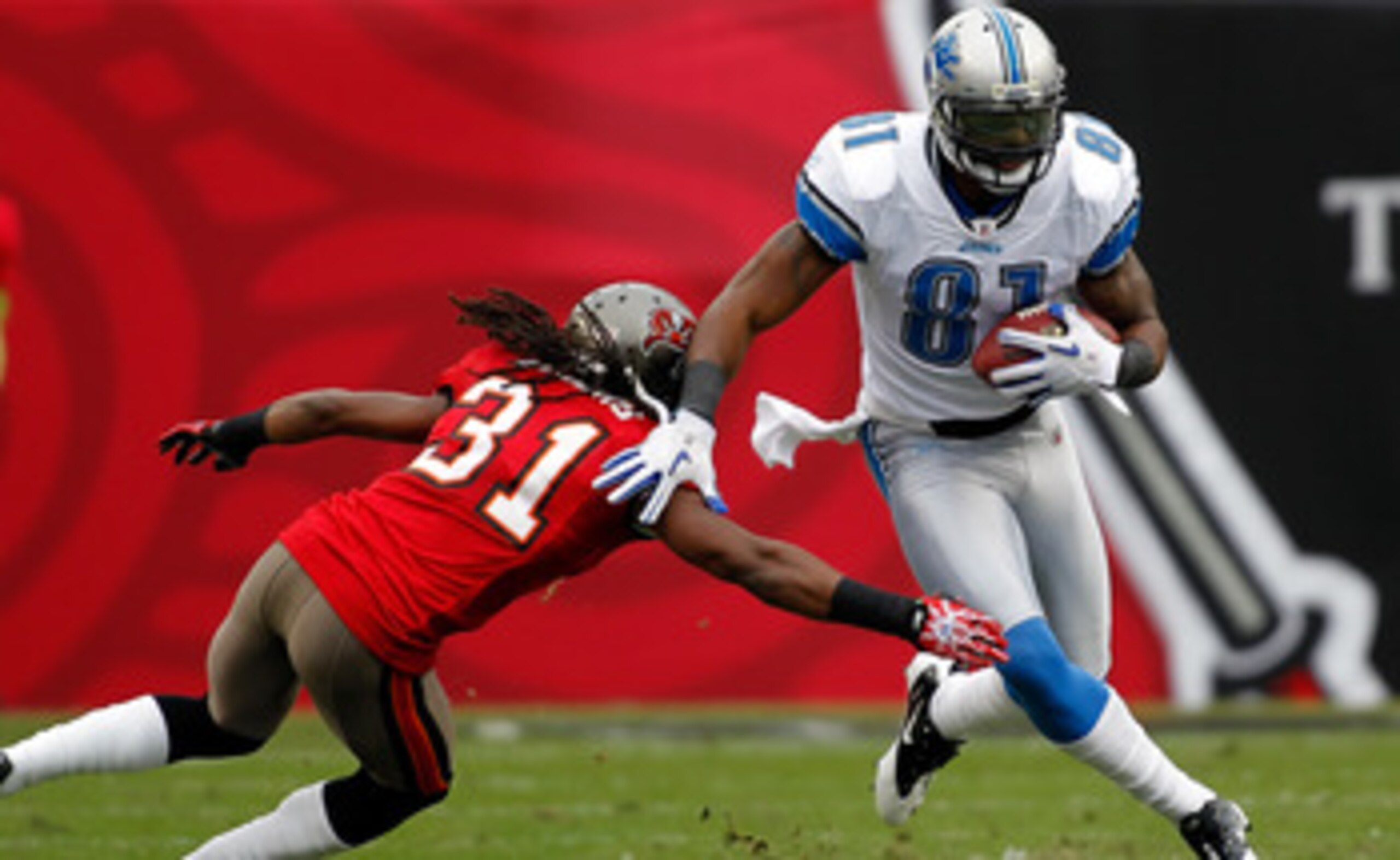 TAMPA, FL - DECEMBER 19:  Receiver Calvin Johnson #81 of the Detroit Lions runs through the tackle of defensive back E.J. Biggers #31 of the Tampa Bay Buccaneers during the game at Raymond James Stadium on December 19, 2010 in Tampa, Florida.  (Photo by J