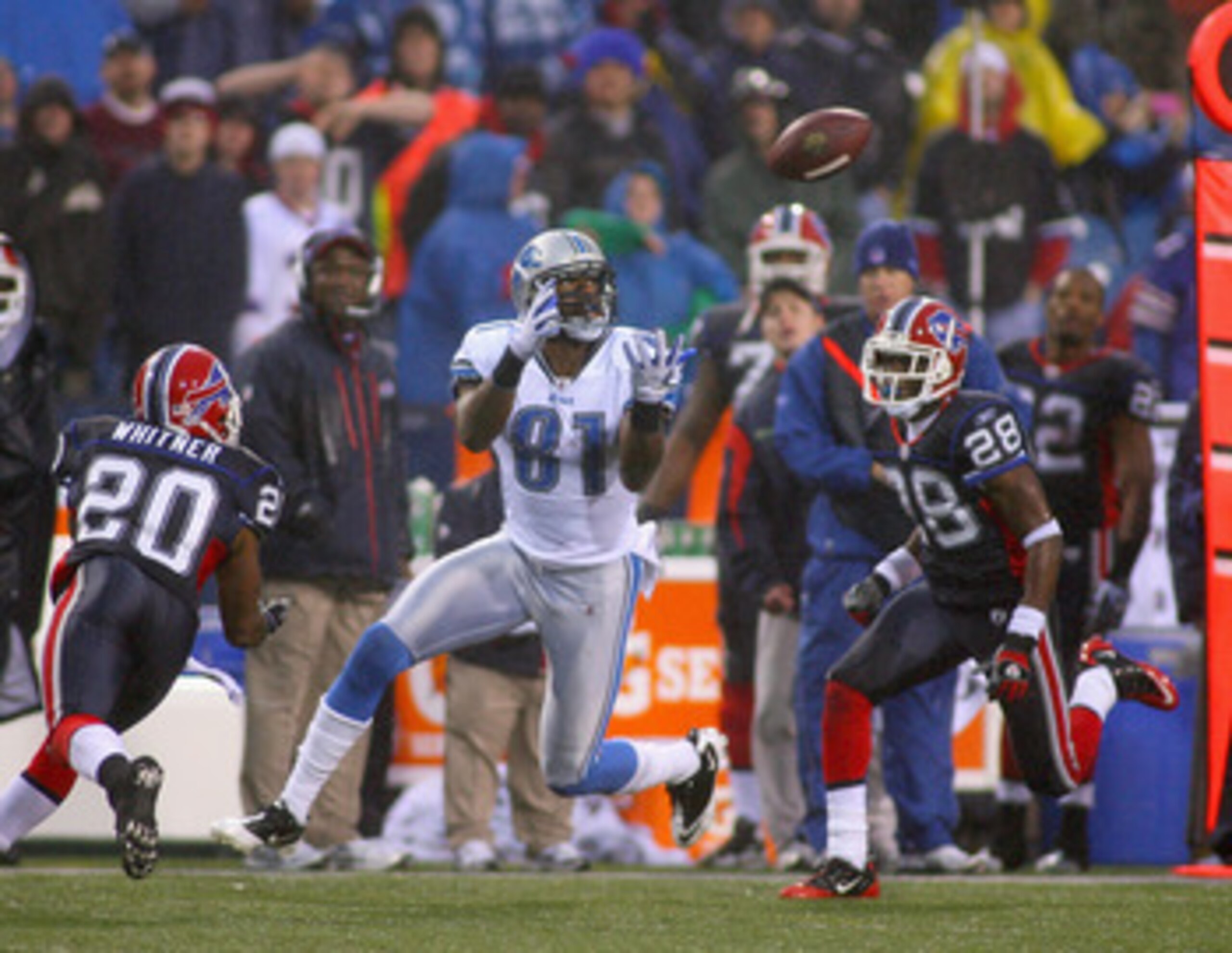ORCHARD PARK, NY - NOVEMBER 14:  Calvin Johnson #81 of the Detroit Lions catches a pass between Donte Whitner #20 and Leodis McKelvin #28 of the Buffalo Bills at Ralph Wilson Stadium on November 14, 2010 in Orchard Park, New York. The Bills won 14-12.  (P