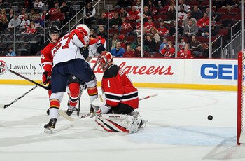 NEWARK, NJ - FEBRUARY 04: Michael Frolik #67 of the Florida Panthers sets up a screen as Johan Hedberg #1 of the New Jersey Devils surrenders a first period goal to Dennis Wideman (not pictured) at the Prudential Center on February 4, 2011 in Newark, New 