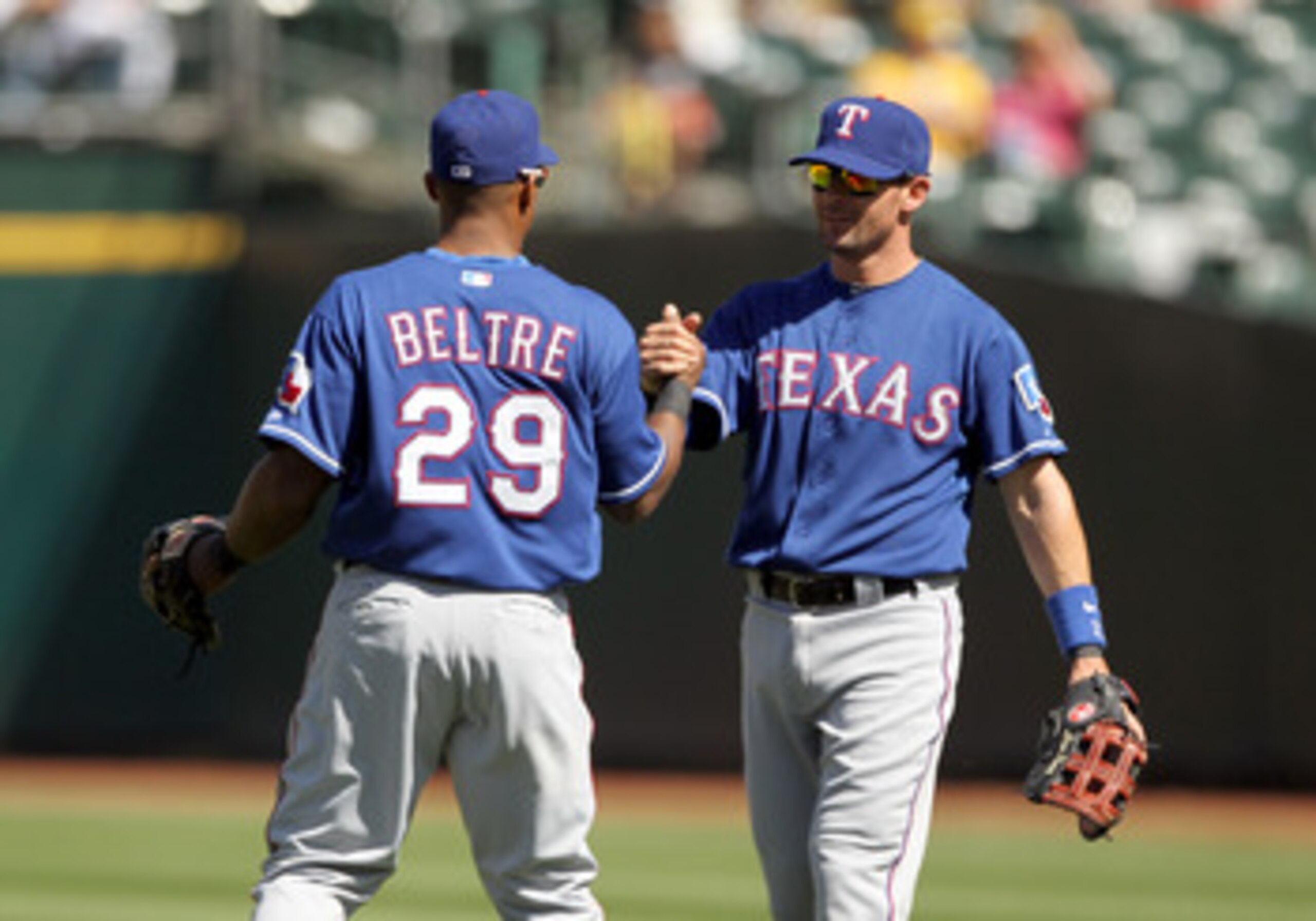 OAKLAND, CA - APRIL 30:  Adrian Beltre #29 and Michael Young #10 of the Texas Rangers celebrate after they beat the Oakland Athletics at Oakland-Alameda County Coliseum on April 30, 2011 in Oakland, California.  (Photo by Ezra Shaw/Getty Images)