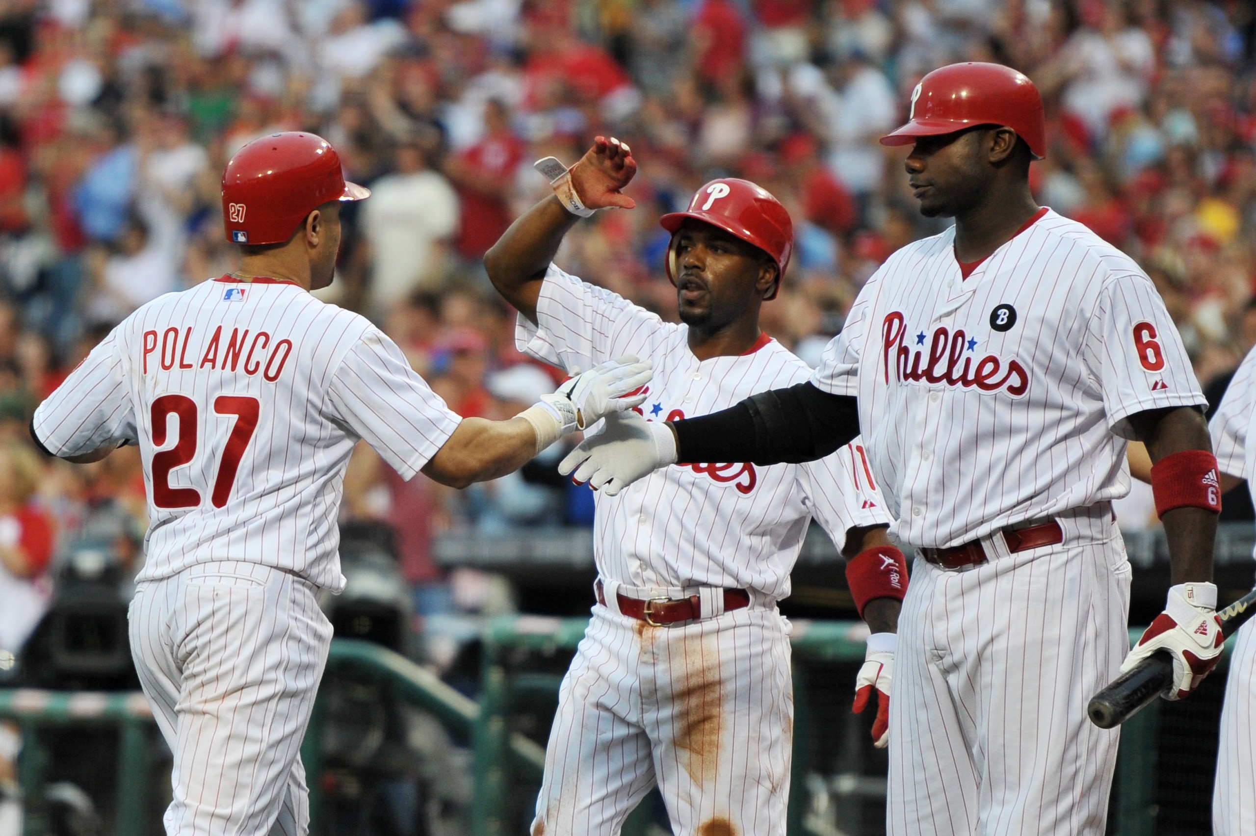 PHILADELPHIA, PA - MAY 23: Placido Polanco #27 of the Philadelphia Phillies gets congratulated by teammates Jimmy Rollins #11 and Ryan Howard #6 after hitting a two run home run during the game against the Cincinnati Reds at Citizens Bank Park on May 23,