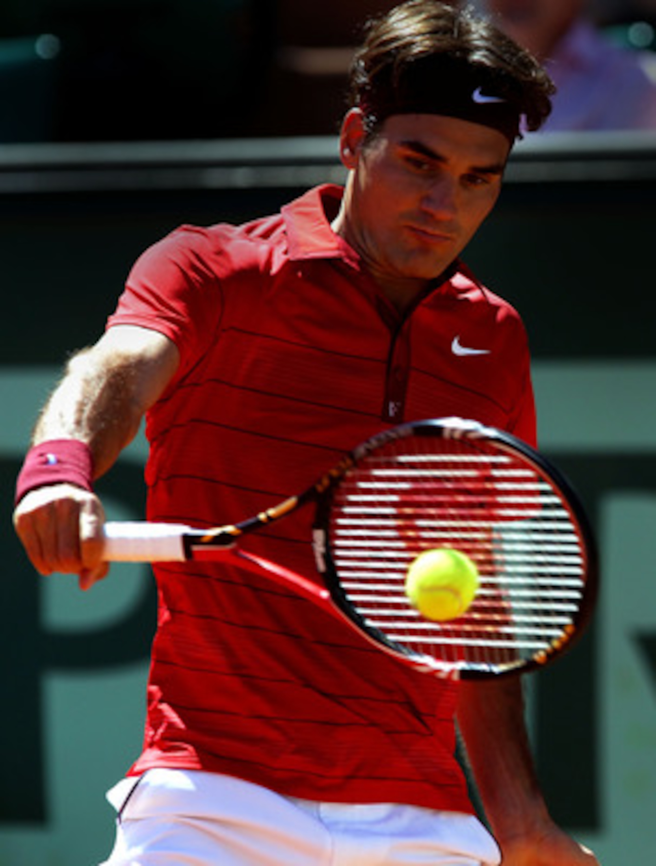 PARIS, FRANCE - MAY 25:  Roger Federer of Switzerland hits a backhand during the men's singles round two match between Maxime Teixera of France and  Roger Federer of Switzerland on day four of the French Open at Roland Garros on May 25, 2011 in Paris, Fra
