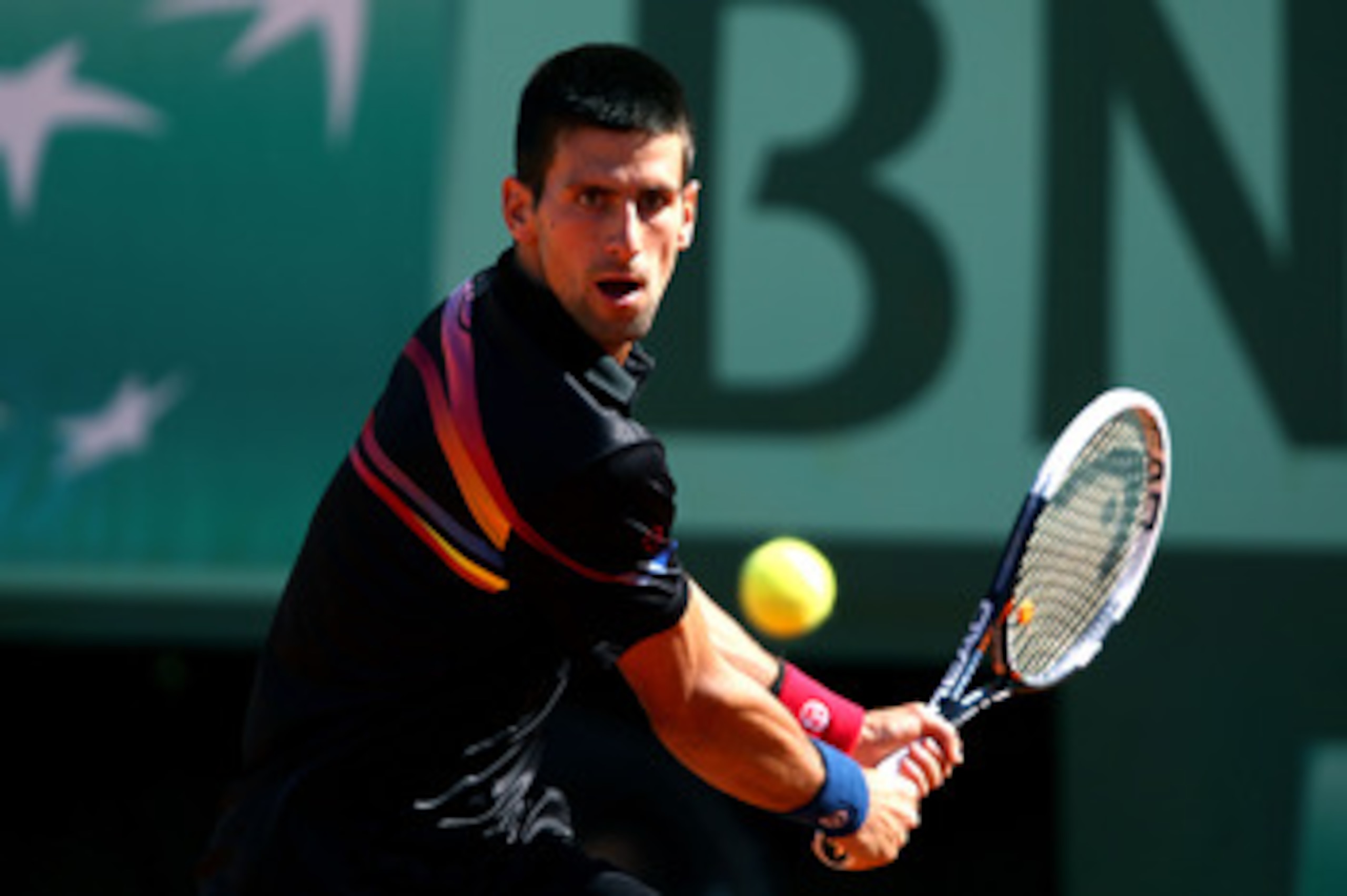 PARIS, FRANCE - MAY 25:  Novak Djokovic of Serbia hits a backhand during the men's singles round two match between Victor Hanescu of Romania and Novak Djokovic of Serbia on day four of the French Open at Roland Garros on May 25, 2011 in Paris, France.  (P