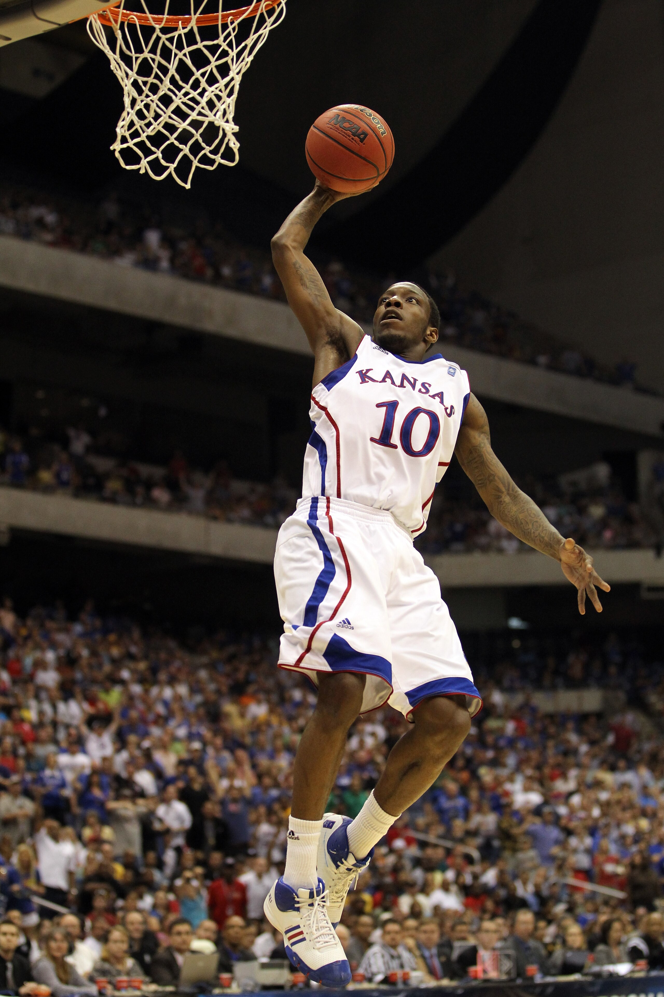SAN ANTONIO, TX - MARCH 27: Tyshawn Taylor #10 of the Kansas Jayhawks dunks against the Virginia Commonwealth Rams during the southwest regional final of the 2011 NCAA men's basketball tournament at the Alamodome on March 27, 2011 in San Antonio, Texas. SAN ANTONIO, TX - MARCH 27: Tyshawn Taylor #10 of the Kansas Jayhawks dunks against the Virginia Commonwealth Rams during the southwest regional final of the 2011 NCAA men's basketball tournament at the Alamodome on March 27, 2011 in San Antonio, Texas.
