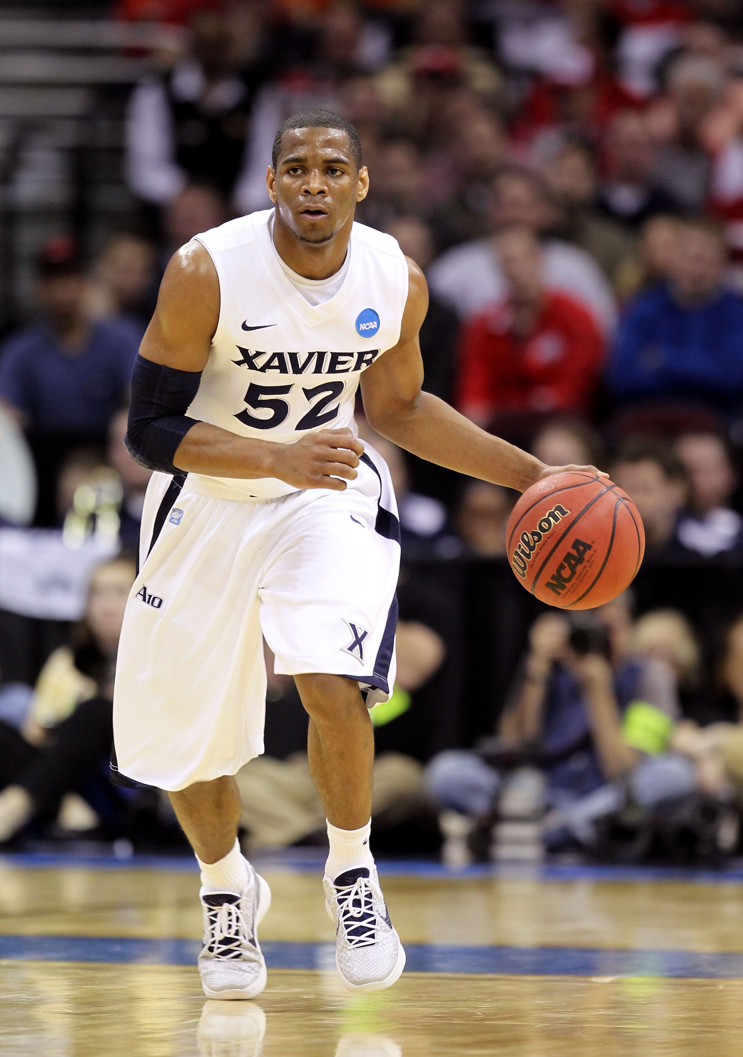 CLEVELAND, OH - MARCH 18: Tu Holloway #52 of the Xavier Musketeers handles the ball against the Marquette Golden Eagles during the second round of the 2011 NCAA men's basketball tournament at Quicken Loans Arena on March 18, 2011 in Cleveland, Ohio. (Pho CLEVELAND, OH - MARCH 18: Tu Holloway #52 of the Xavier Musketeers handles the ball against the Marquette Golden Eagles during the second round of the 2011 NCAA men's basketball tournament at Quicken Loans Arena on March 18, 2011 in Cleveland, Ohio. (Pho