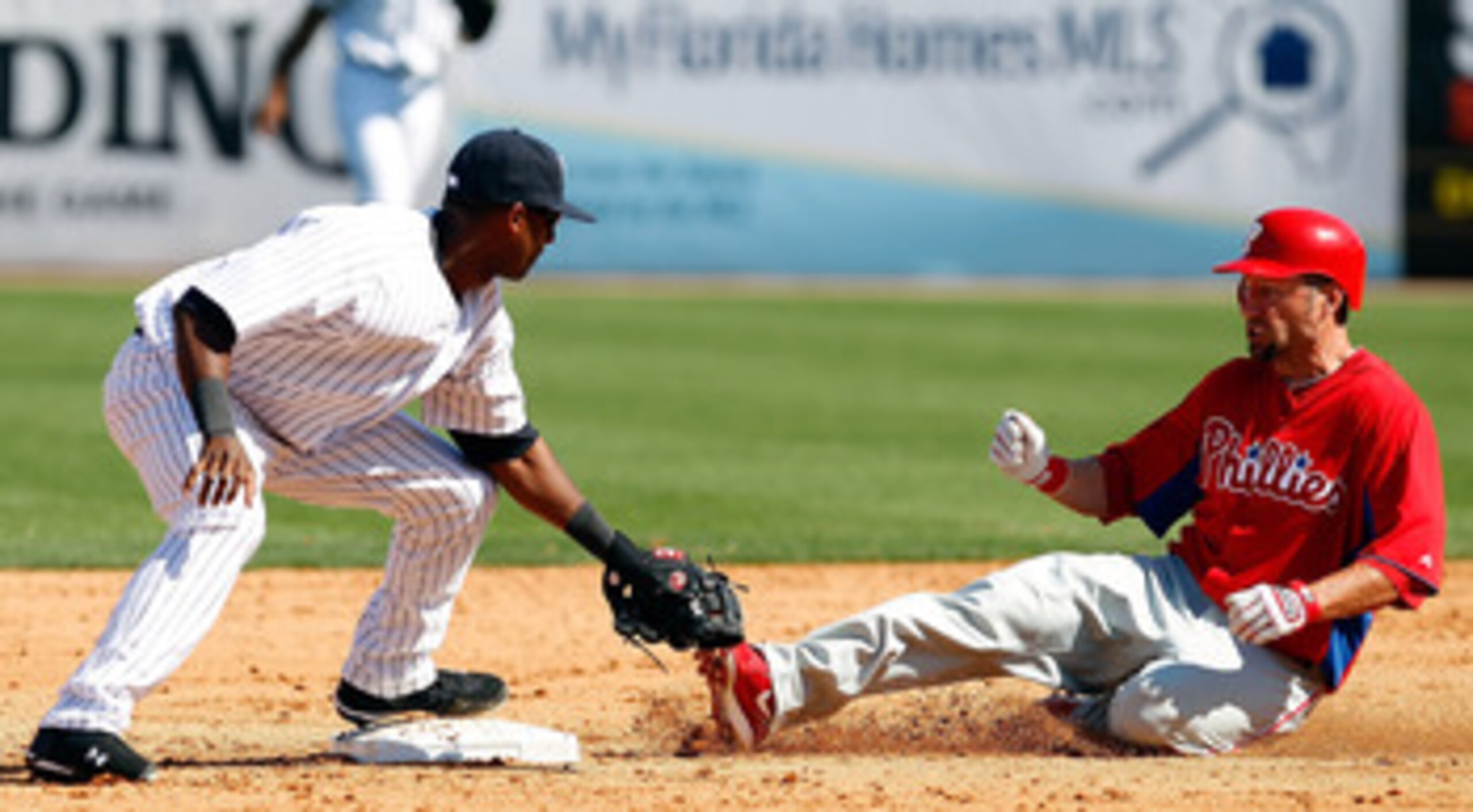 TAMPA, FL - FEBRUARY 26:  Shortstop Eduardo Nunez #67 of the New York Yankees takes the throw at second as designated hitter Ross Gload #7 of the Philadelphia Phillies slides in safely during a Grapefruit League Spring Training Game at George M. Steinbren