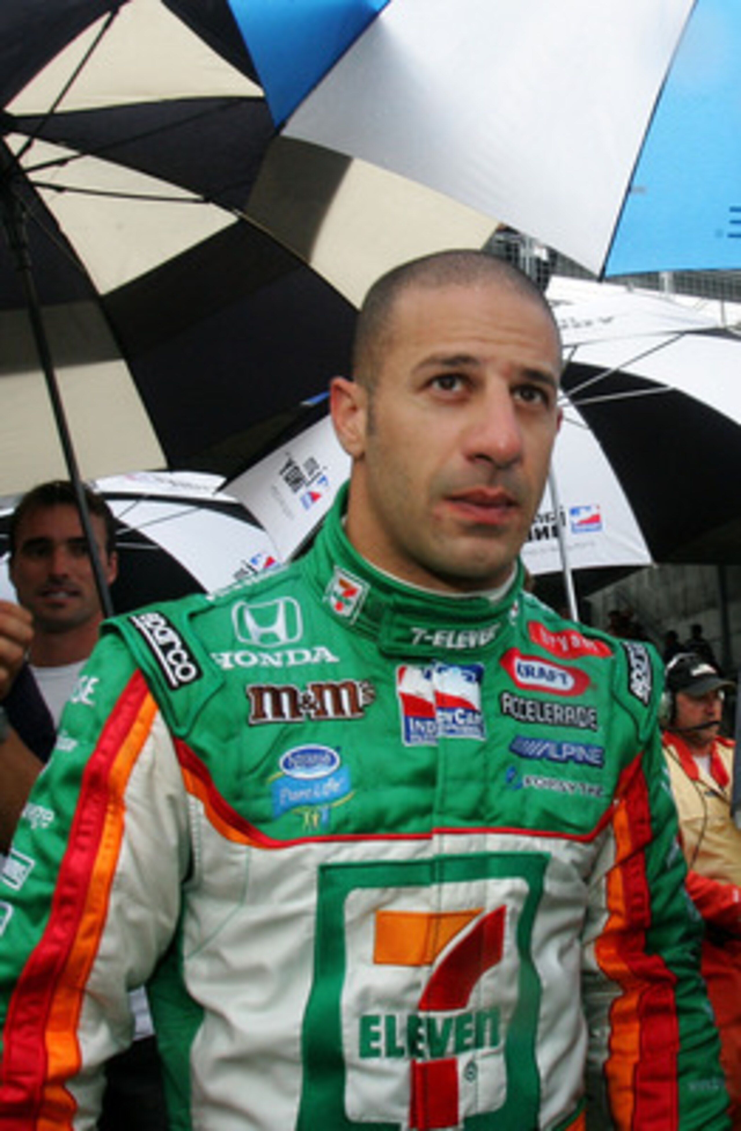 INDIANAPOLIS - MAY 27:  Tony Kanaan, driver of the #11 Team 7-Eleven Andretti Green Racing Dallara Honda, walks towards the garage during a red flag rain delay during the IRL IndyCar Series 91st running of the Indianapolis 500 at the Indianapolis Motor Sp