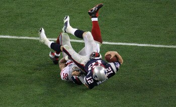 GLENDALE, AZ - FEBRUARY 03:  Quarterback Tom Brady #12 of the New England Patriots lies on his back after being sacked by defensive end Michael Strahan #92 of the New York Giants in the third quarter during Super Bowl XLII on February 3, 2008 at the Unive