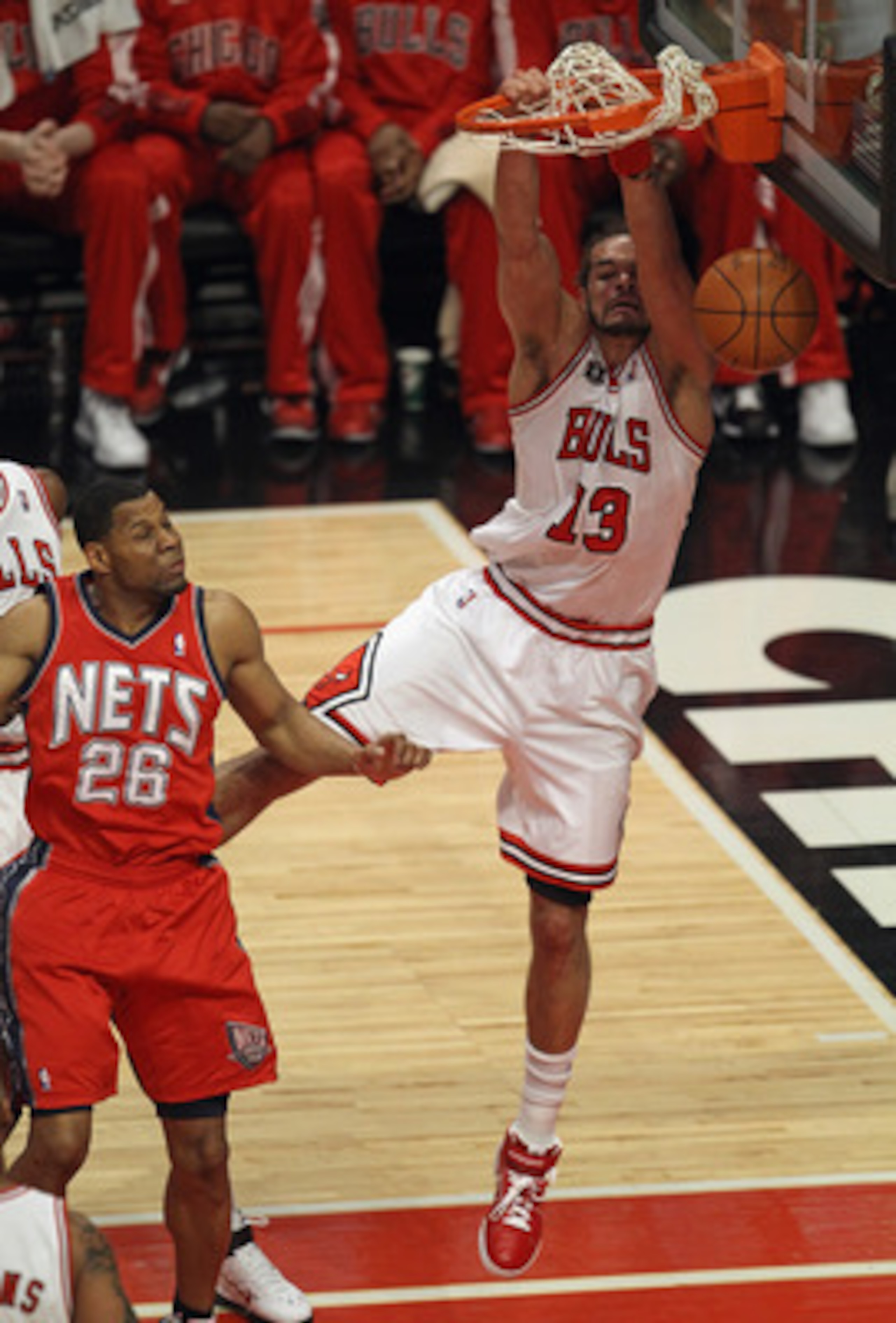 CHICAGO, IL - APRIL 13: Joakim Noah #13 of the Chicago Bulls dunks the ball over Stephen Graham #26 of the New Jersey Nets at United Center on April 13, 2011 in Chicago, Illinois. NOTE TO USER: User expressly acknowledges and agrees that, by downloading a