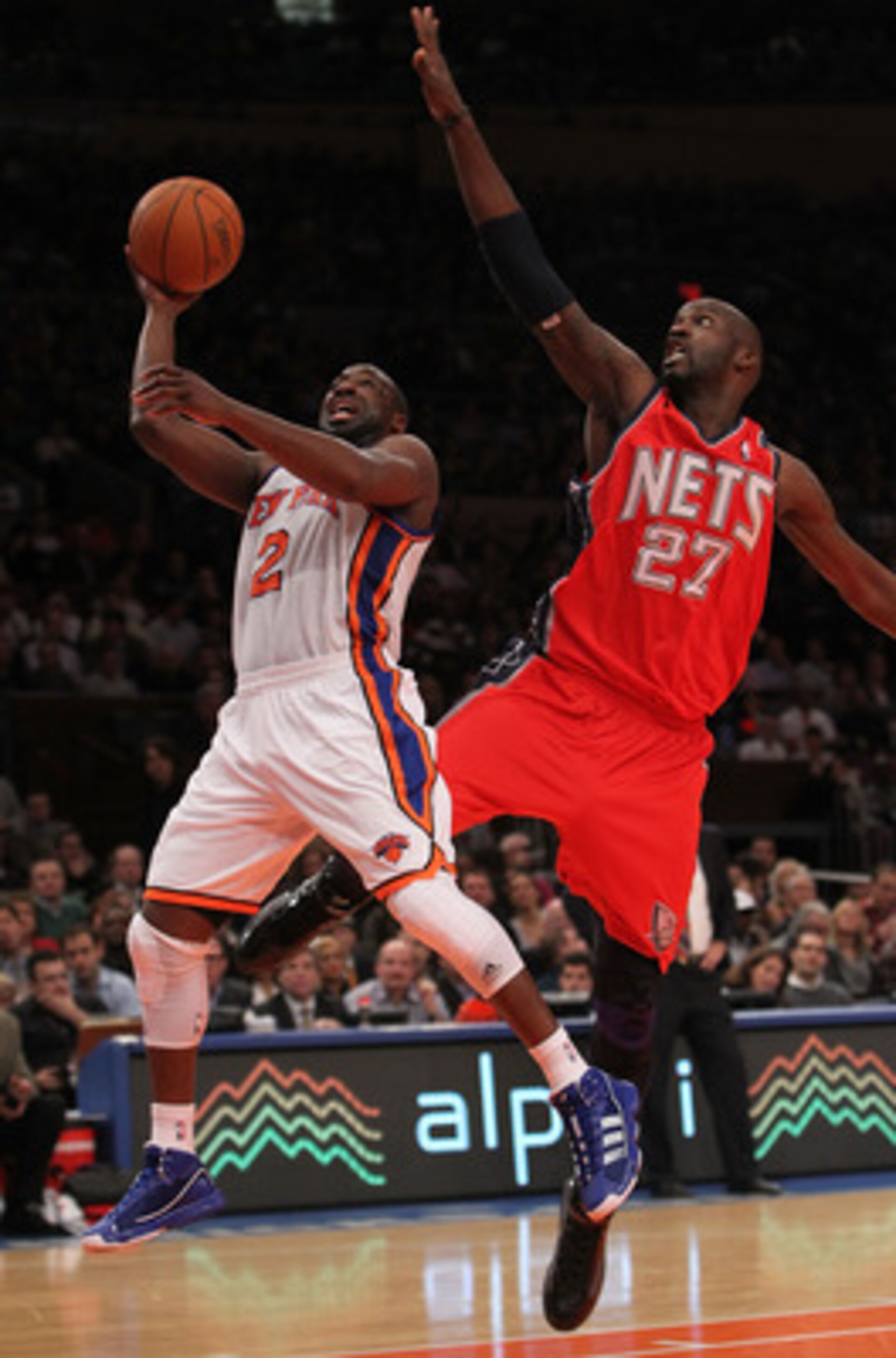NEW YORK, NY - NOVEMBER 30:  Raymond Felton #2 of the New York Knicks shoots the ball under the block of Johan Petro #27 of the New Jersey Nets on November 30, 2010 at Madison Square Garden in New York City. NOTE TO USER: User expressly acknowledges and a