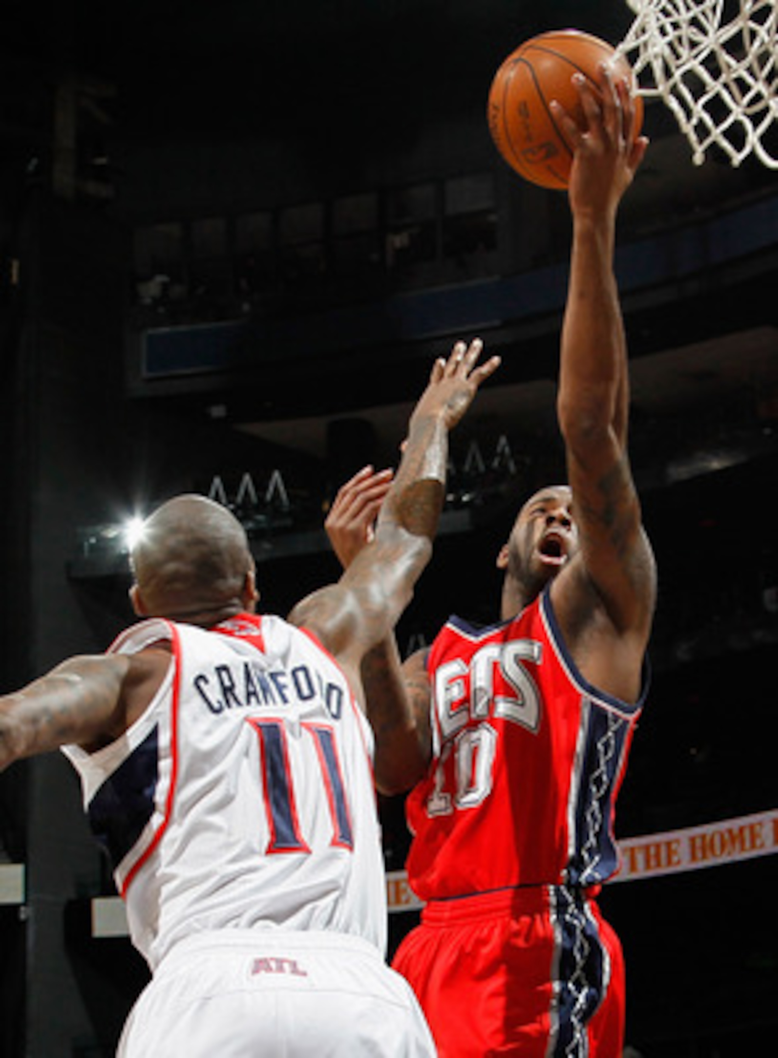 ATLANTA, GA - DECEMBER 07:  Damion James #10  of the New Jersey Nets drives the basket against Jamal Crawford #11 of the Atlanta Hawks at Philips Arena on December 7, 2010 in Atlanta, Georgia.  NOTE TO USER: User expressly acknowledges and agrees that, by