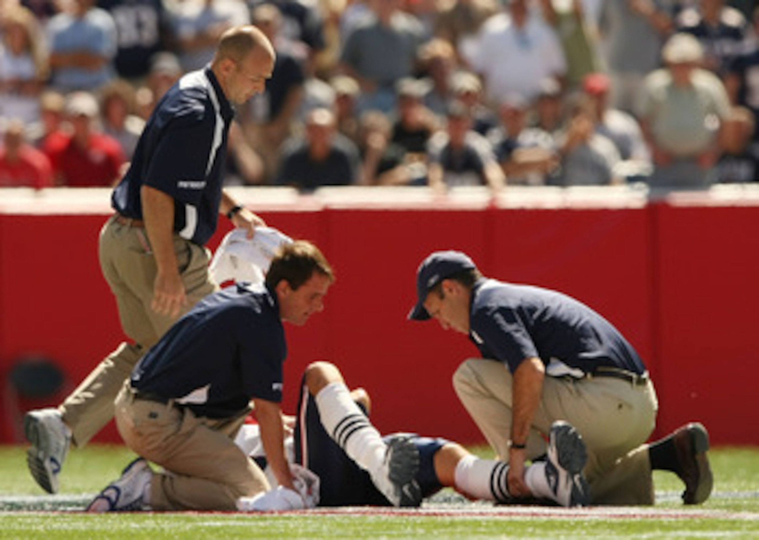 FOXBORO, MA - SEPTEMBER 7:  Quarterback Tom Brady #12 of the New England Patriots is assesed by the medical staff after he sustained an injury to his left knee in the first quarter against the Kansas City Chiefs at Gillette Stadium September 7, 2008 in Fo