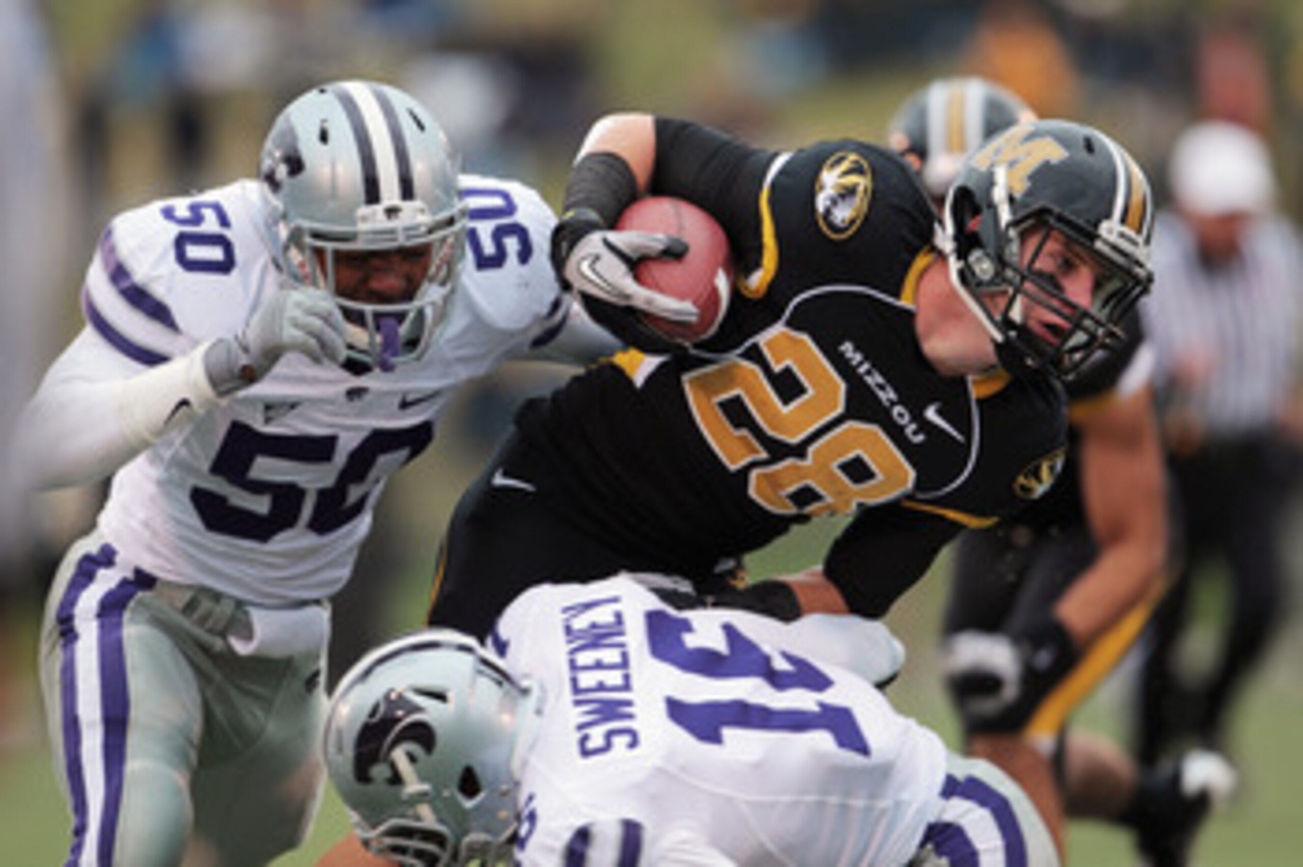 COLUMBIA, MO - NOVEMBER 13:  Receiver T.J. Moe #28 of the Missouri Tigers carries the ball as Tre Walker #50 and Terrance Sweeney #16 of the Kansas State Wildcats defend during the game on November 13, 2010 at Faurot Field/Memorial Stadium in Columbia, Mi