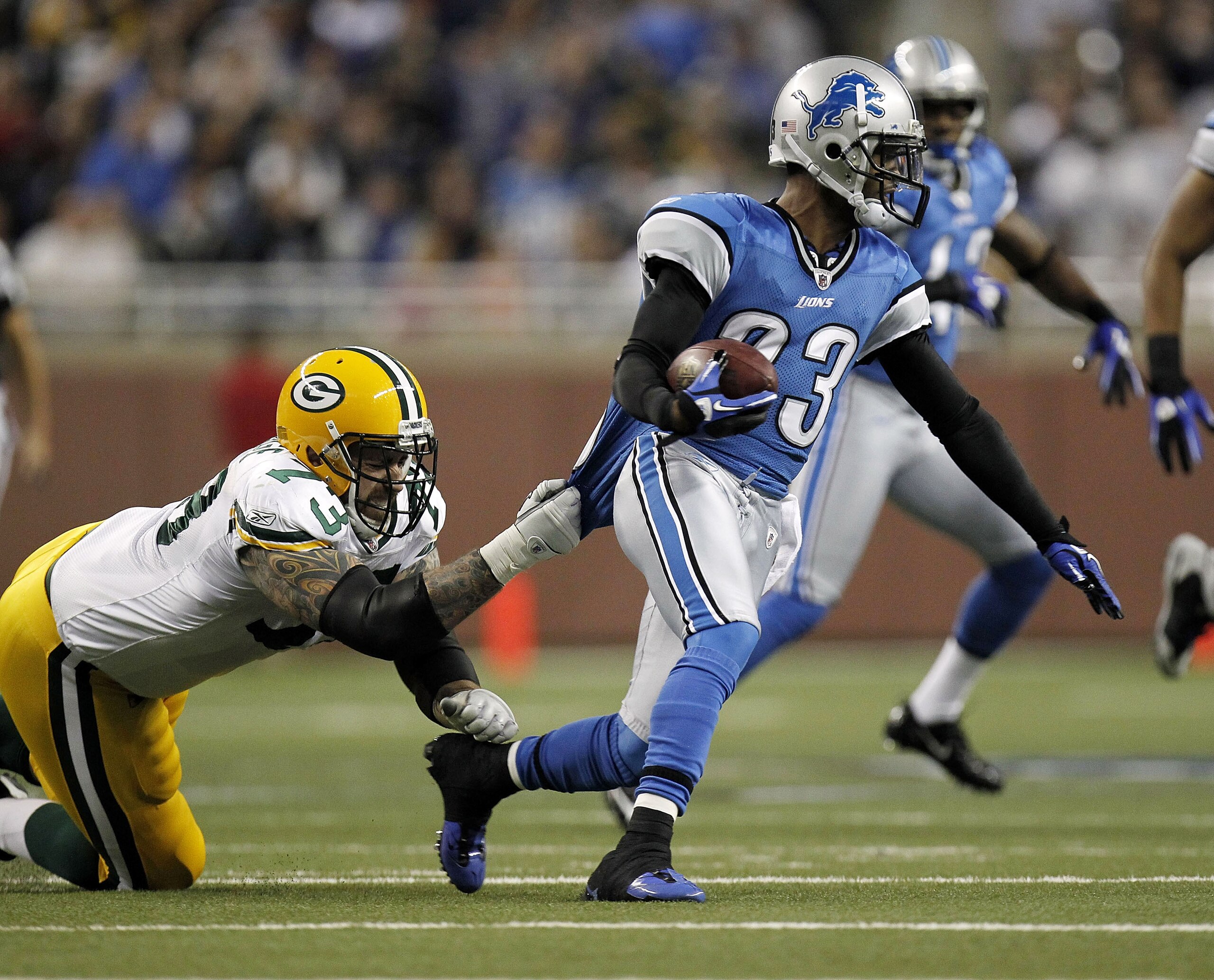 DETROIT, MI - DECEMBER 12:  Chris Houston #23 of the Detroit Lions tries to get around the tackle after picking up a first quarter fumble of Daryn Colledge #73 of the Green Bay Packers on December 12, 2010 at Ford Field in Detroit, Michigan.  (Photo by Gr