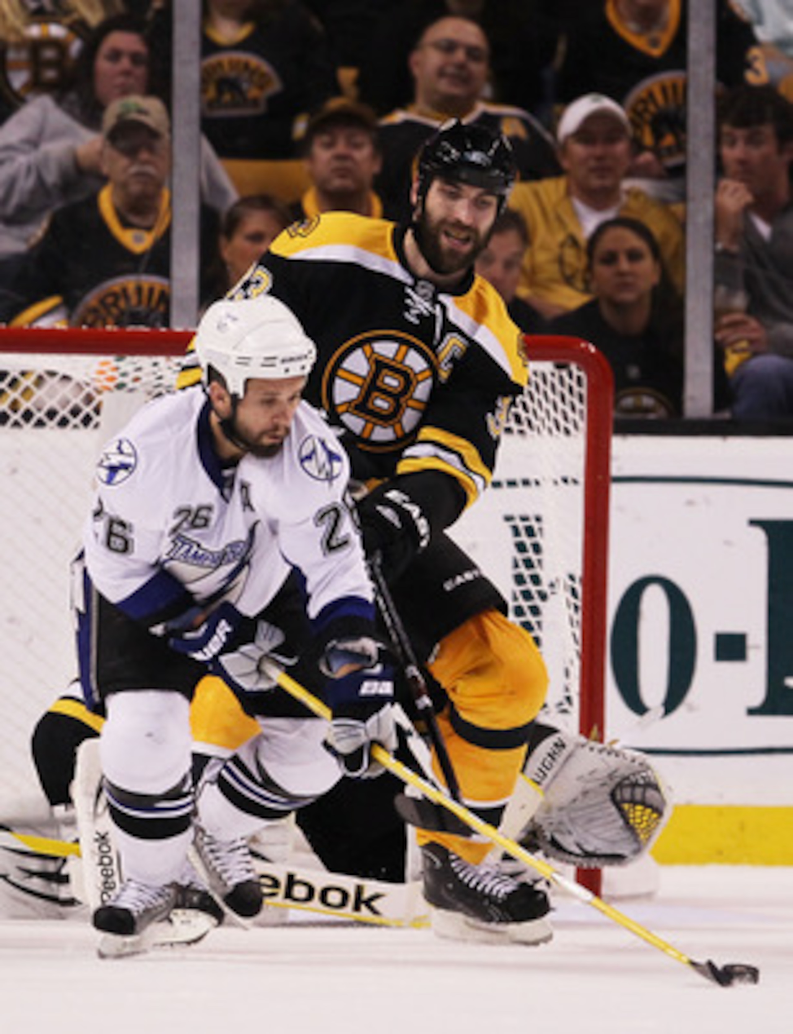 BOSTON, MA - MAY 23:  Martin St. Louis #26 of the Tampa Bay Lightning and Zdeno Chara #33 of the Boston Bruins vie for the puck in Game Five of the Eastern Conference Finals during the 2011 NHL Stanley Cup Playoffs at TD Garden on May 23, 2011 in Boston,