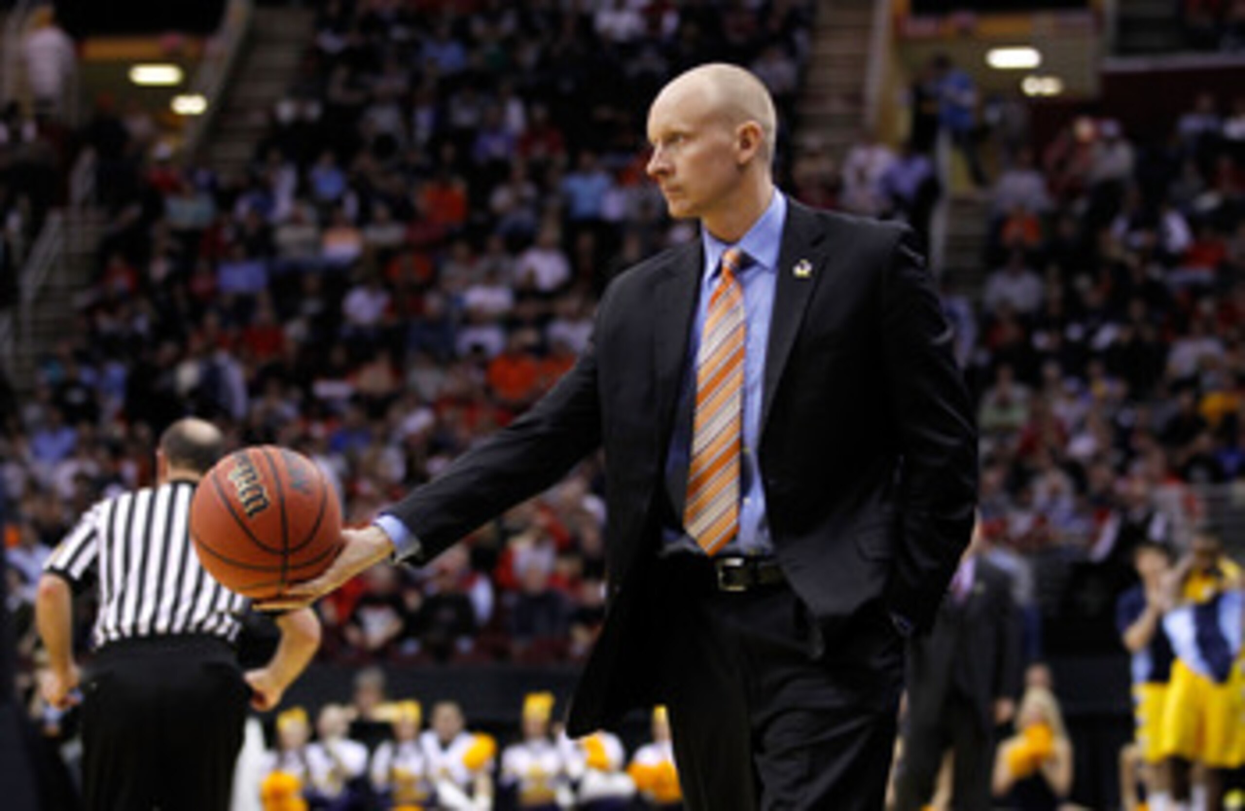 CLEVELAND, OH - MARCH 18: Head coach Chris Mack of the Xavier Musketeers tosses the ball to a referee during the game against the Marquette Golden Eagles during the second round of the 2011 NCAA men's basketball tournament at Quicken Loans Arena on March 