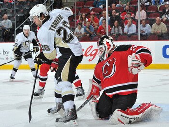 NEWARK, NJ - OCTOBER 11: Martin Brodeur #30 of the New Jersey Devils puts his stick between the legs of Eric Tangradi #26 of the Pittsburgh Penguins as he defends his net during the first period at the Prudential Center on October 11, 2010 in Newark, New