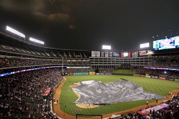 ARLINGTON, TX - MAY 24:  Workers cover the field at Rangers Ballpark in Arlington before a rain delay between the Chicago White Sox and Texas Rangers  on May 24, 2011 in Arlington, Texas.  (Photo by Ronald Martinez/Getty Images)