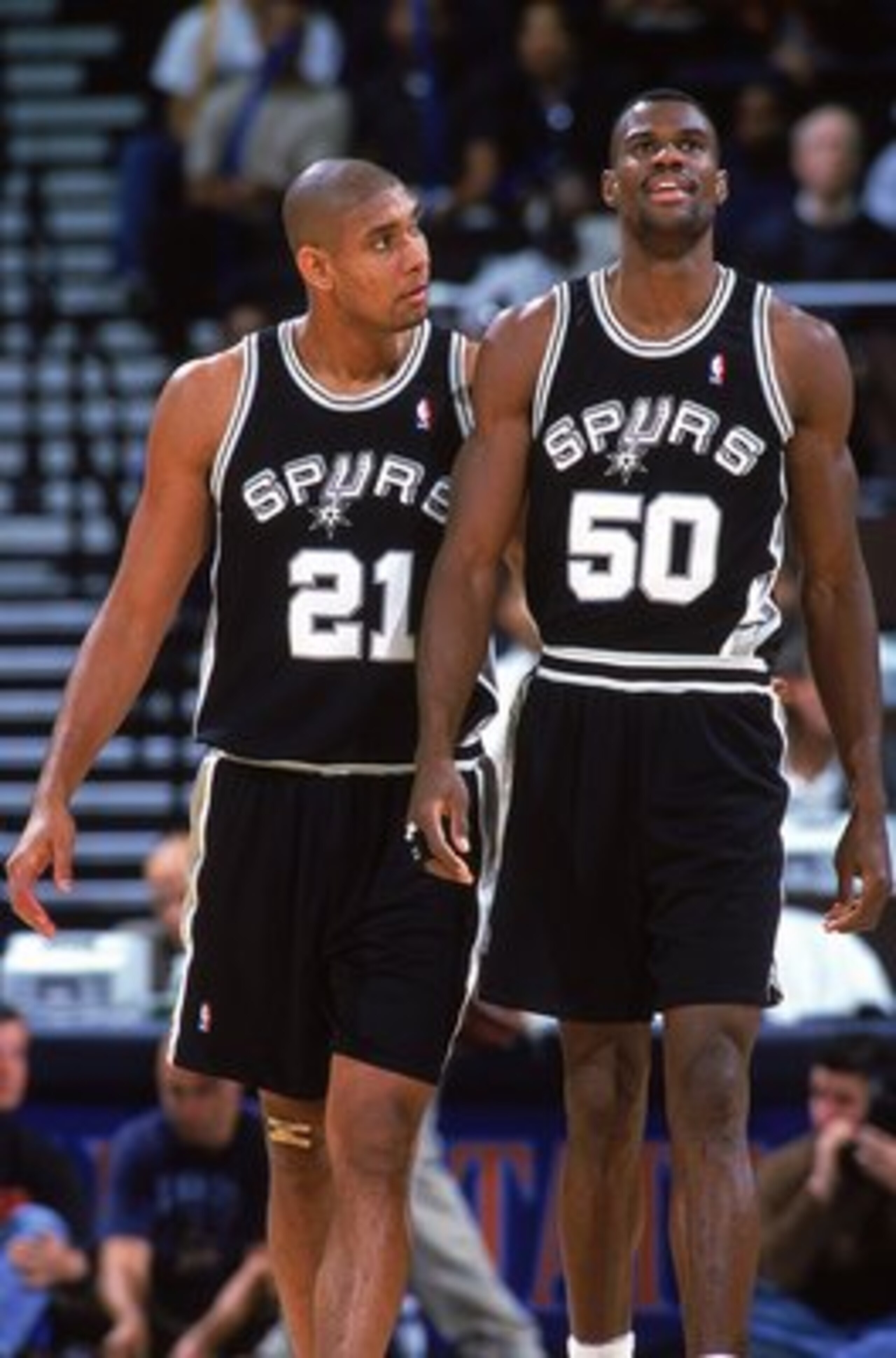 9 Nov 1999: David Robinson #50 of the San Antonio Spurs walks on the court with teammate Tim Duncan #21during a game against the Golden State Warriors at the Oakland Coliseum in Oakland, California. The Spurs defeated the Warriors 118-89.  Mandatory Credi