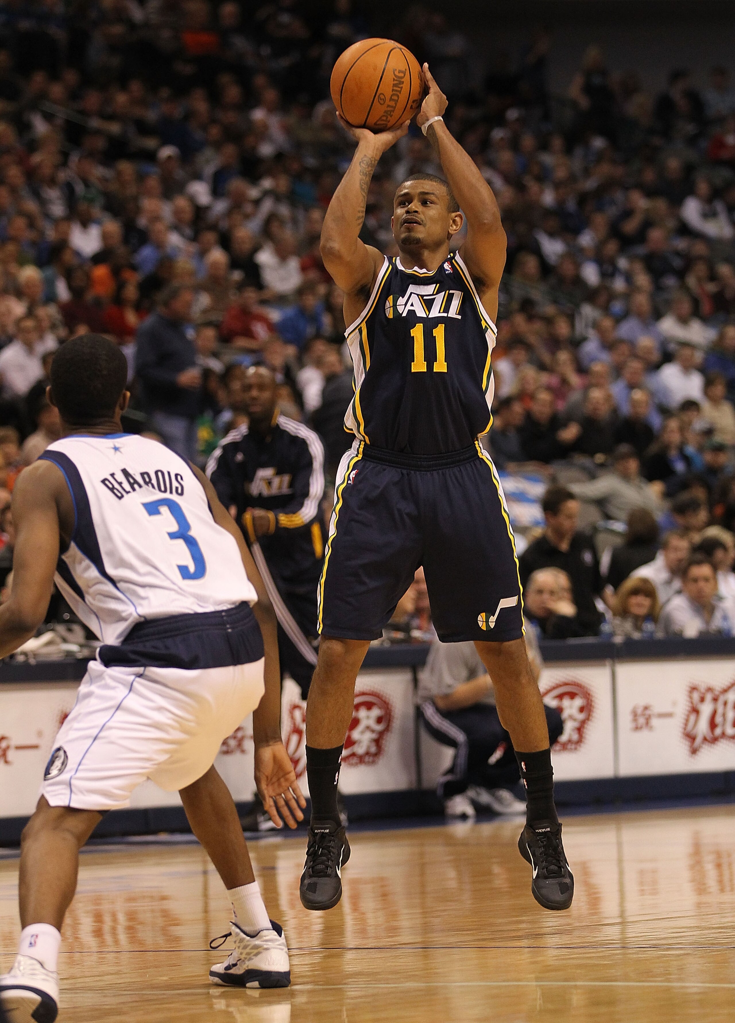 DALLAS, TX - FEBRUARY 23:  Guard Earl Watson #11 of the Utah Jazz takes a shot against Rodrigue Beaubois #3 of the Dallas Mavericks at American Airlines Center on February 23, 2011 in Dallas, Texas.  NOTE TO USER: User expressly acknowledges and agrees th