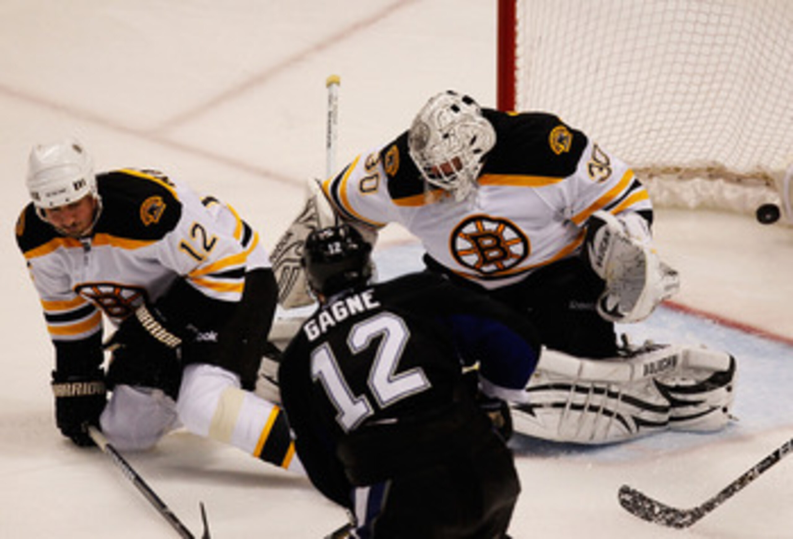 TAMPA, FL - MAY 21: Simon Gagne #12 of the Tampa Bay Lightning scores a third period goal past Tomas Kaberle #12 and Tim Thomas #30 of the Boston Bruins in Game Four of the Eastern Conference Finals during the 2011 NHL Stanley Cup Playoffs at St Pete Tim TAMPA, FL - MAY 21: Simon Gagne #12 of the Tampa Bay Lightning scores a third period goal past Tomas Kaberle #12 and Tim Thomas #30 of the Boston Bruins in Game Four of the Eastern Conference Finals during the 2011 NHL Stanley Cup Playoffs at St Pete Tim